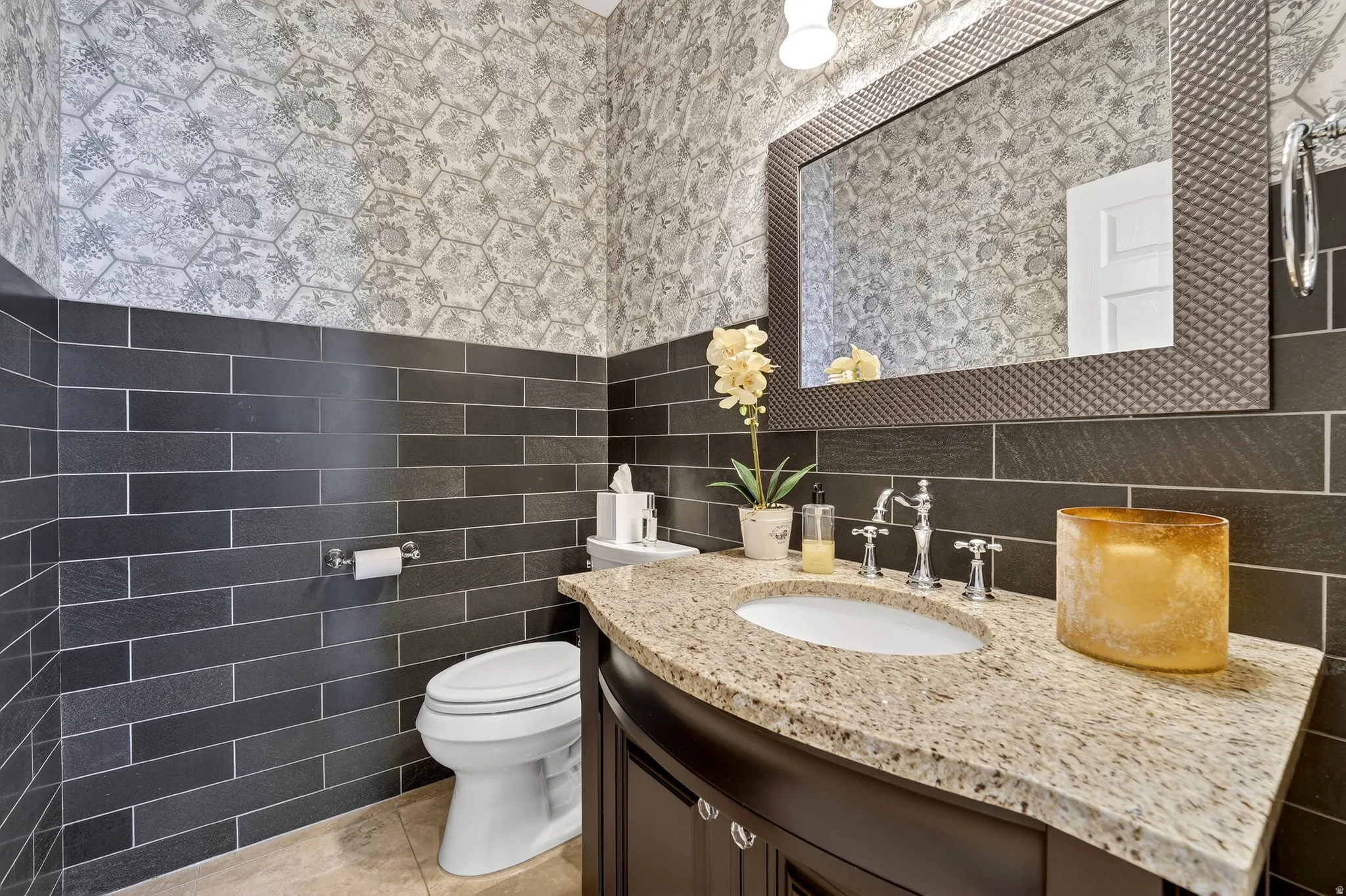 Main floor 1/2 bathroom with vanity, tile walls, light tile patterned flooring, and wallpapered walls