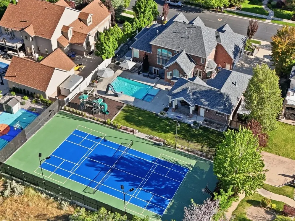 Expansive property featuring a private tennis/pickleball courts, swimming pool, playground and large grassy areas