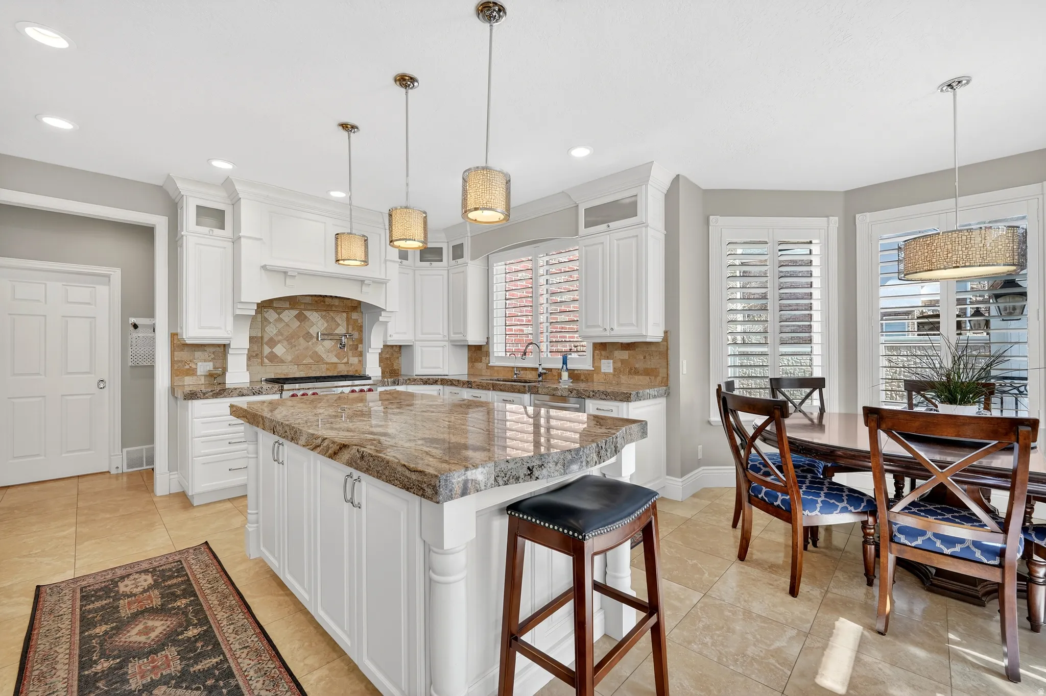 Kitchen with white cabinets, glass fronted cabinets, a kitchen breakfast bar, and a center island