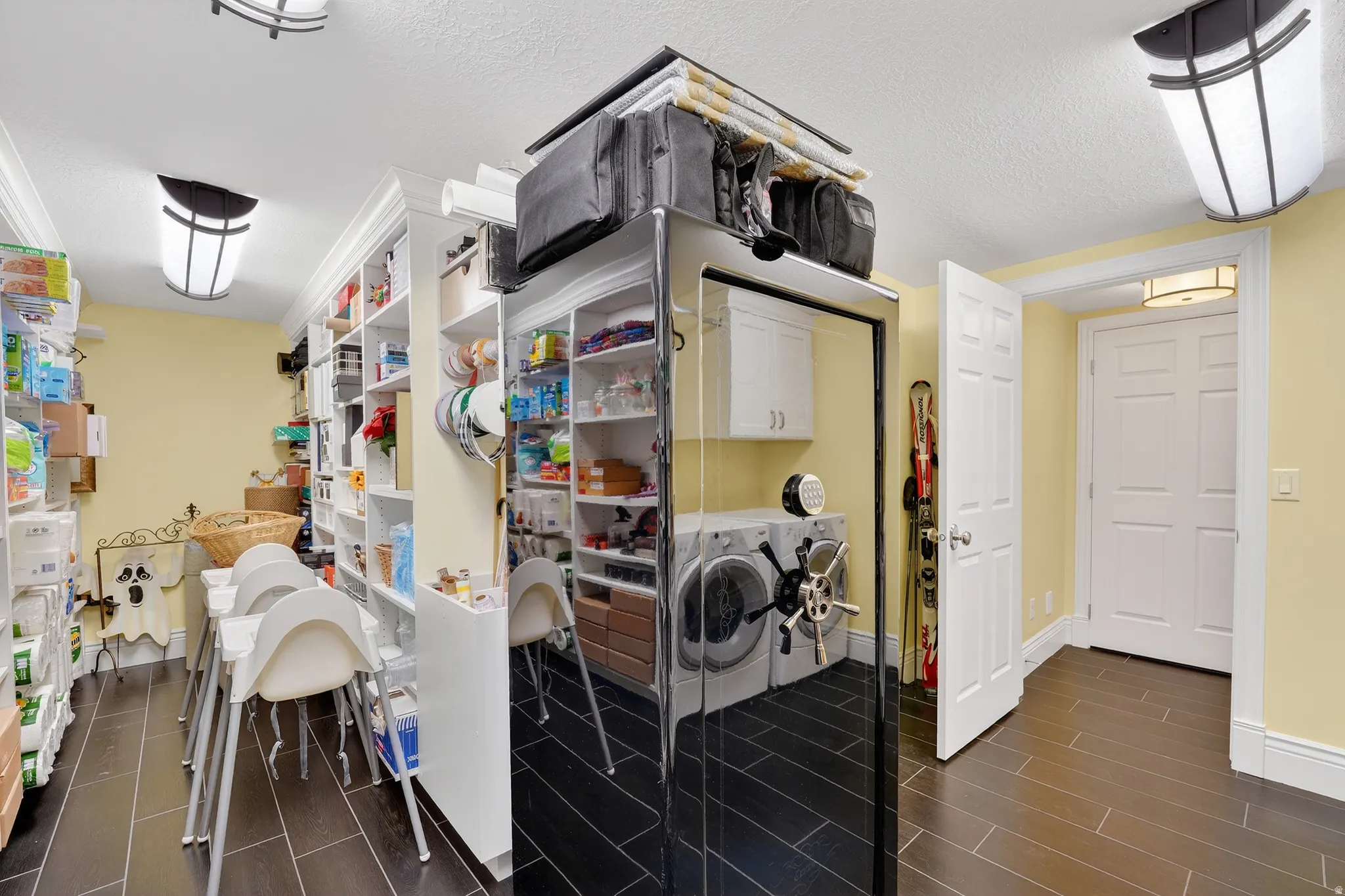 Laundry room with washer and clothes dryer, wood finish floors, cabinet space, and a textured ceiling