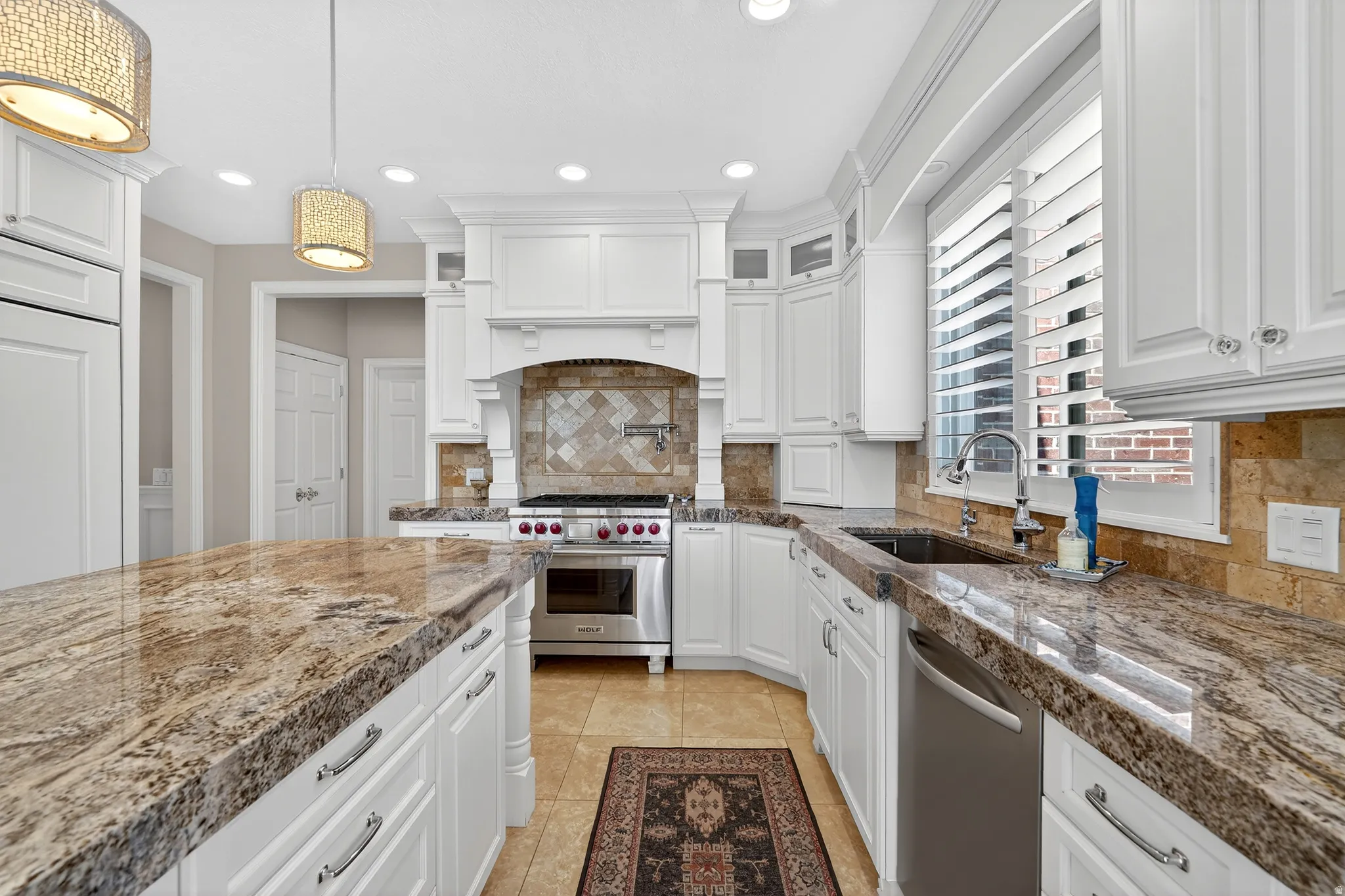 Kitchen featuring white cabinetry, stainless steel appliances, decorative backsplash, and glass fronted cabinets