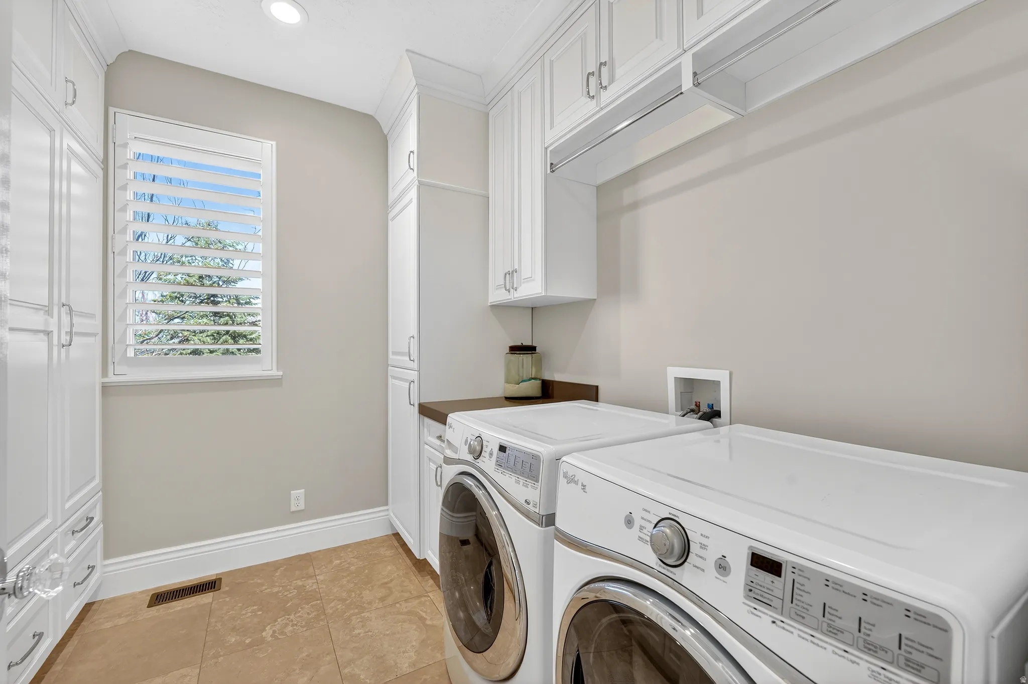 Laundry room with cabinet space, separate washer and dryer, and recessed lighting