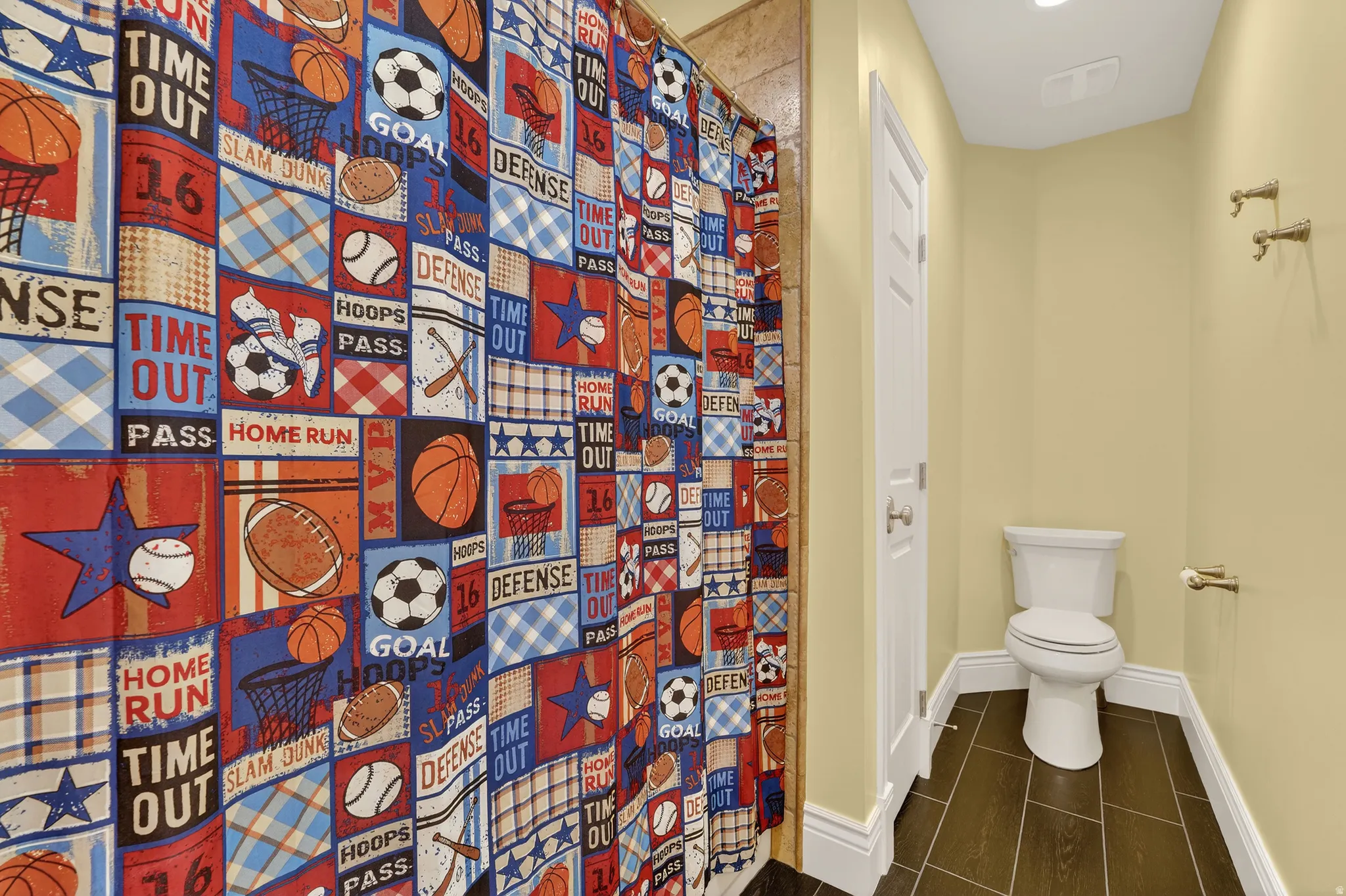 Full bath with a shower with curtain and toilet