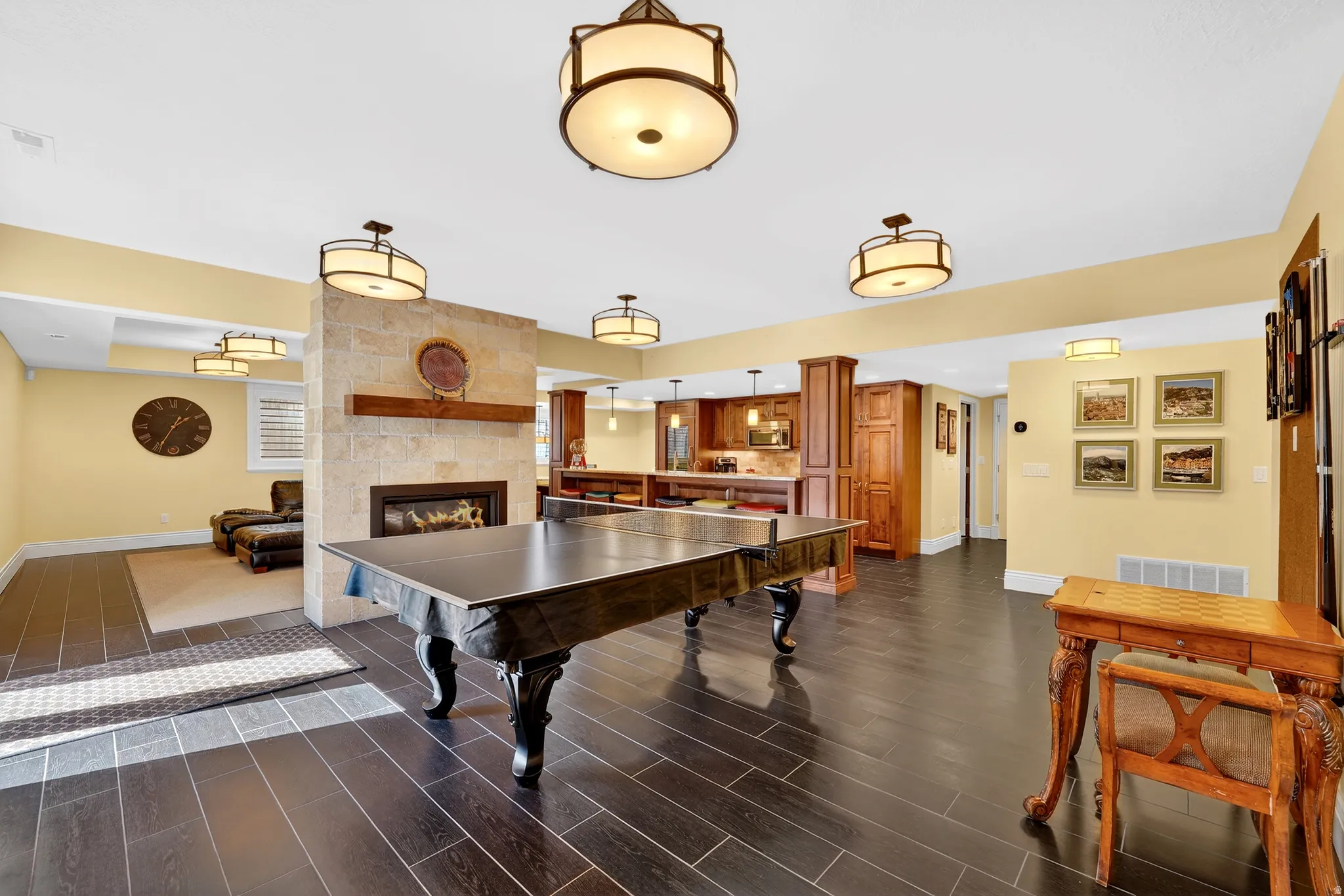 Game room with a tiled fireplace and wood finish floors