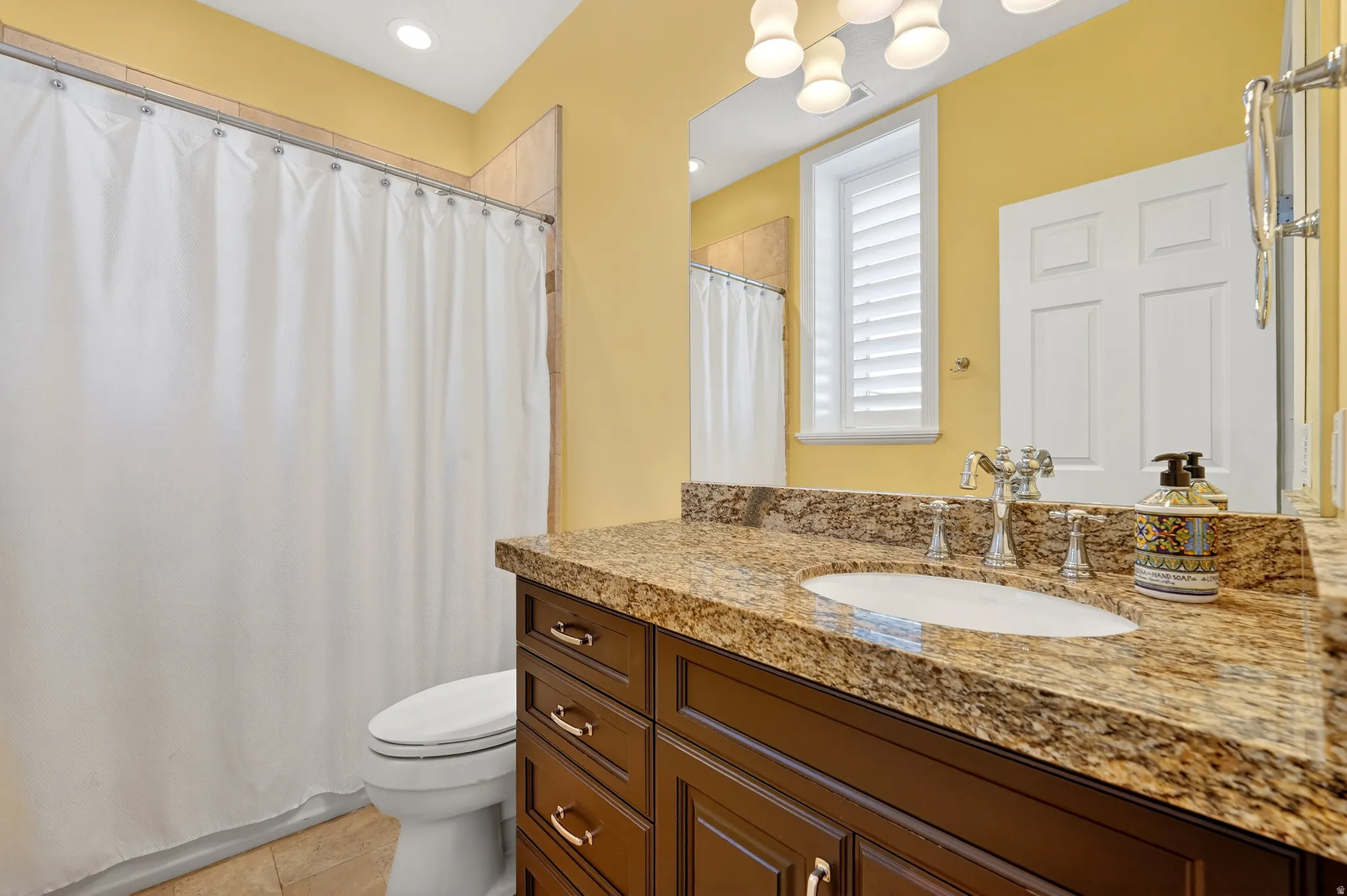 Bathroom with vanity, a shower with shower curtain, light tile patterned floors, and recessed lighting
