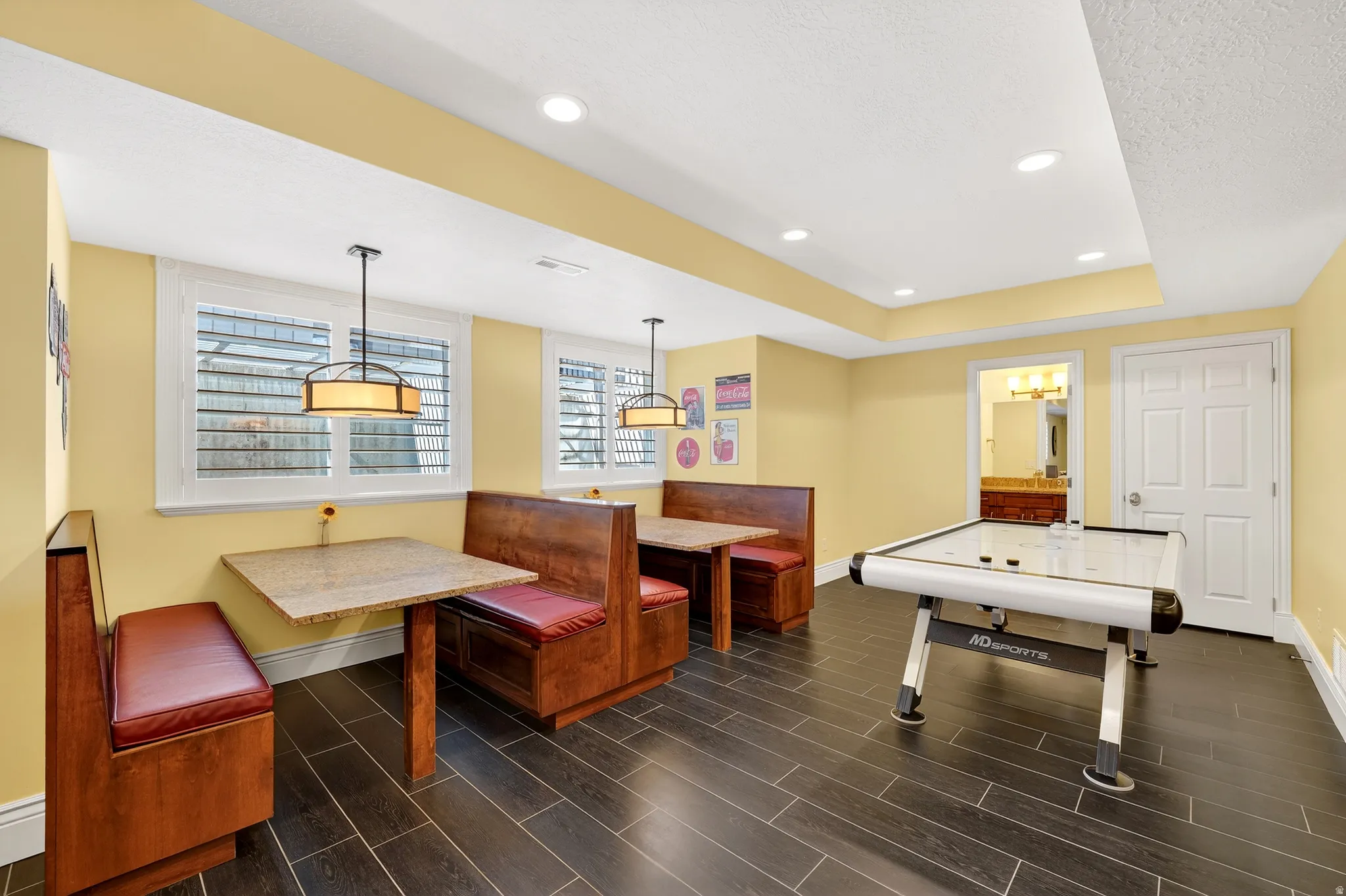 Rec room featuring a tray ceiling, wood finish floors, recessed lighting, and a textured ceiling