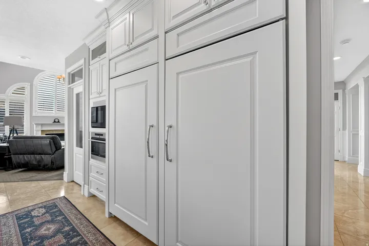 Kitchen with recessed lighting, white cabinets, a fireplace, oven, and black microwave