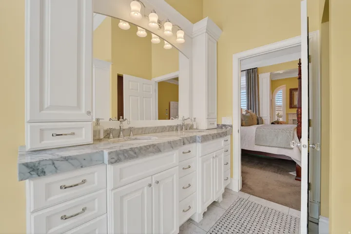 Full bath featuring double vanity, light carpet, connected bathroom, and light tile patterned floors
