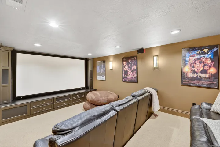 Carpeted cinema room with a textured ceiling and recessed lighting