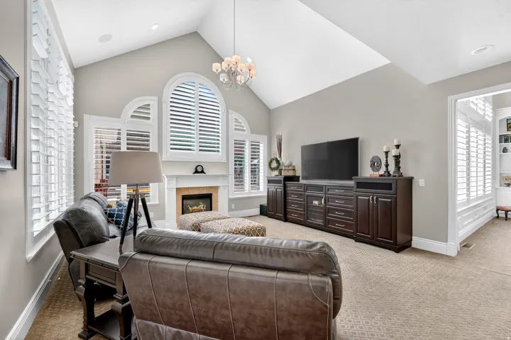 Family Room area featuring built in cabinets, light carpet, a high ceiling, a fireplace, and hanging lights