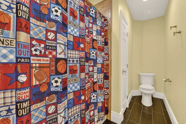 Full bath with a shower with curtain and toilet