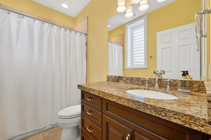Bathroom with vanity, a shower with shower curtain, light tile patterned floors, and recessed lighting