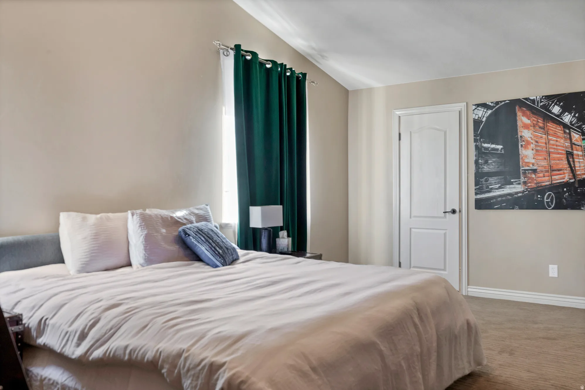 Bedroom with carpet floors and vaulted ceiling