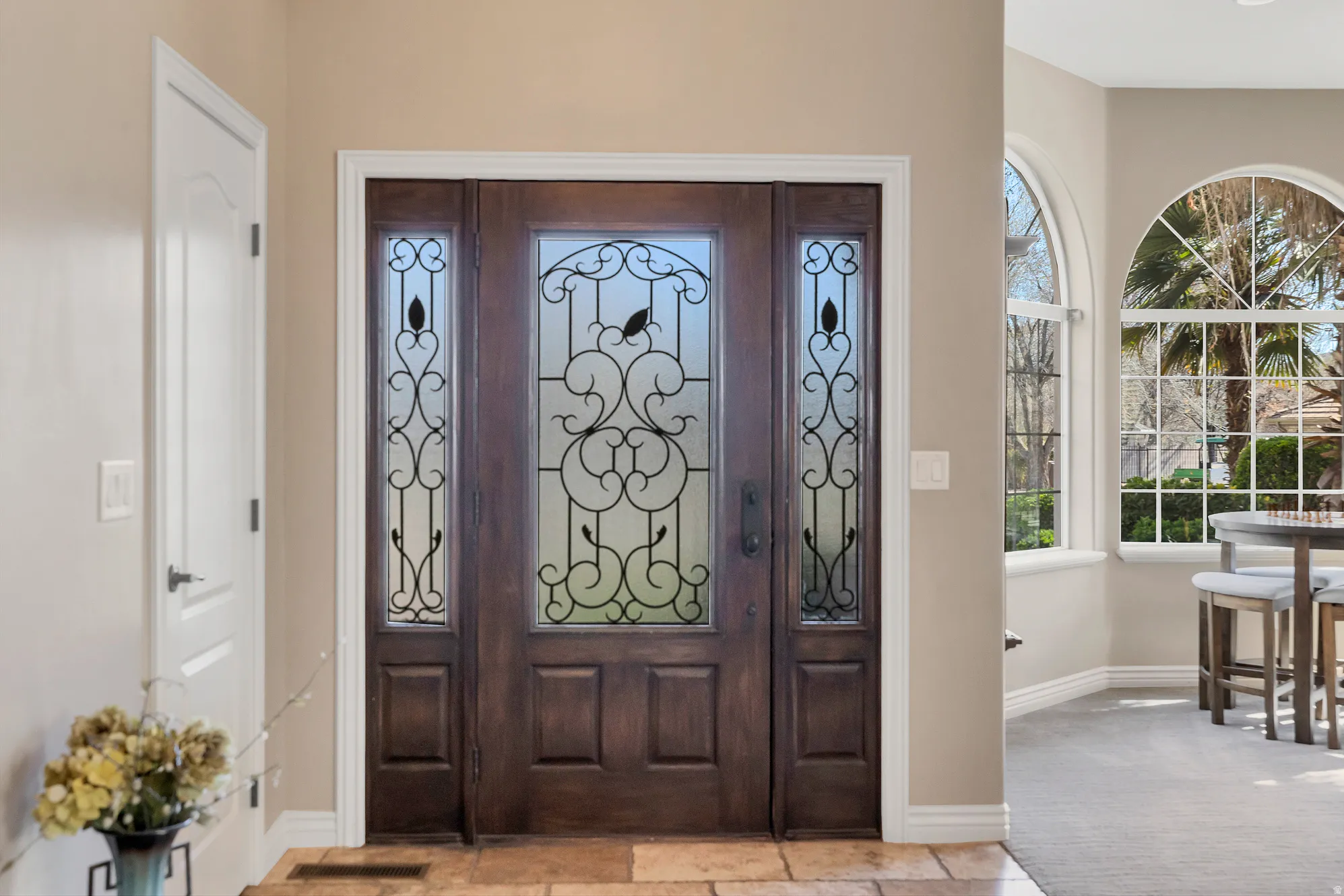 Foyer entrance with baseboards and light carpet