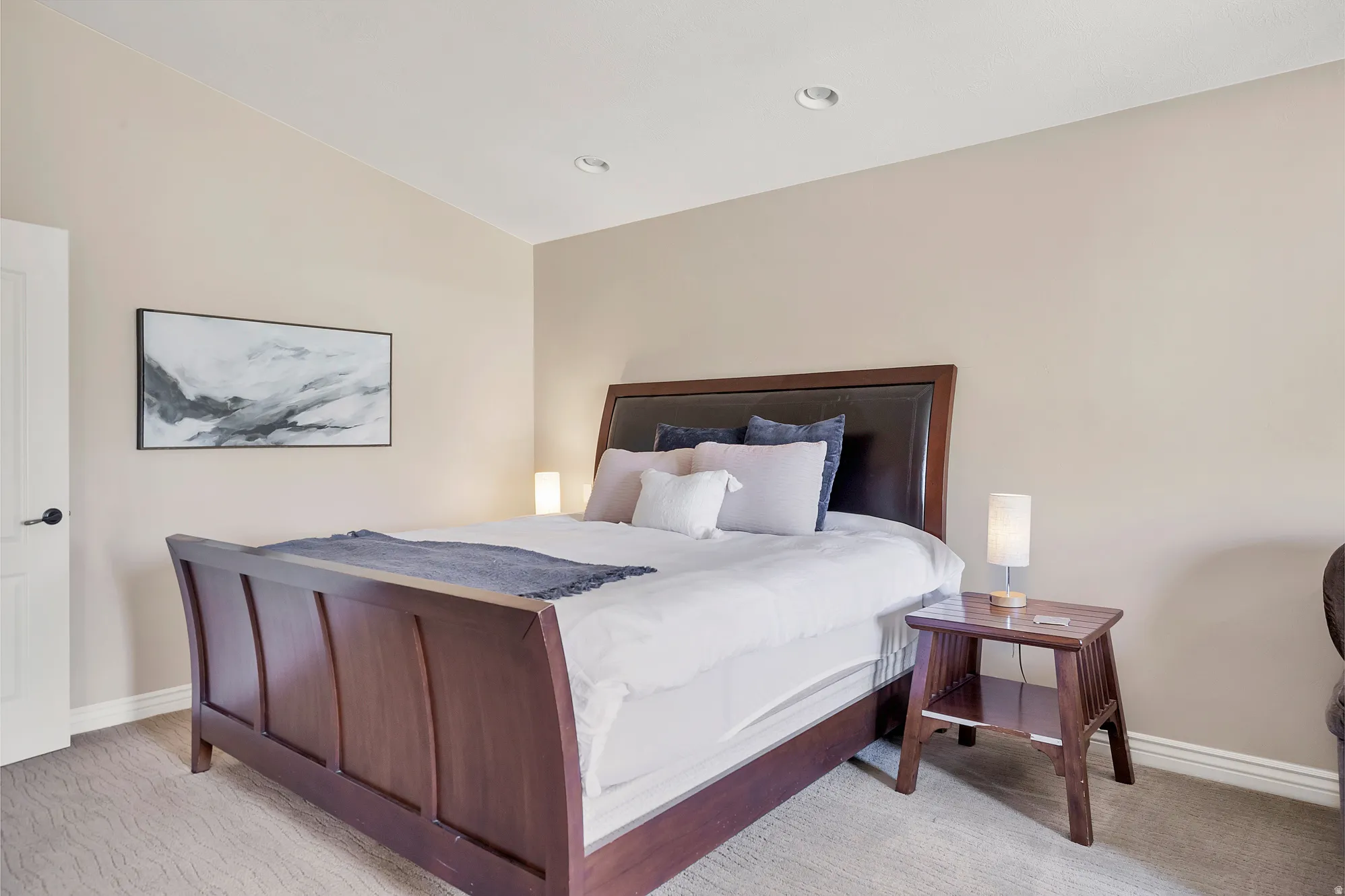 Bedroom with vaulted ceiling and light colored carpet