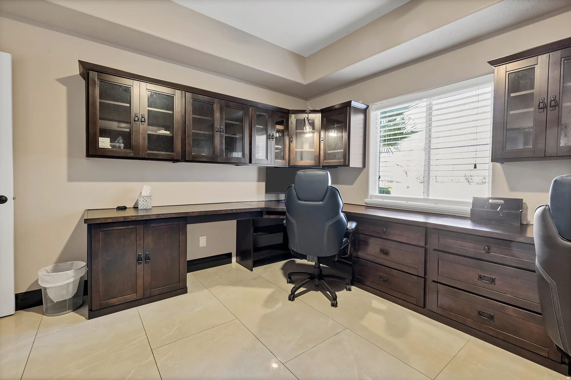 Office area featuring built in study area and light tile patterned floors