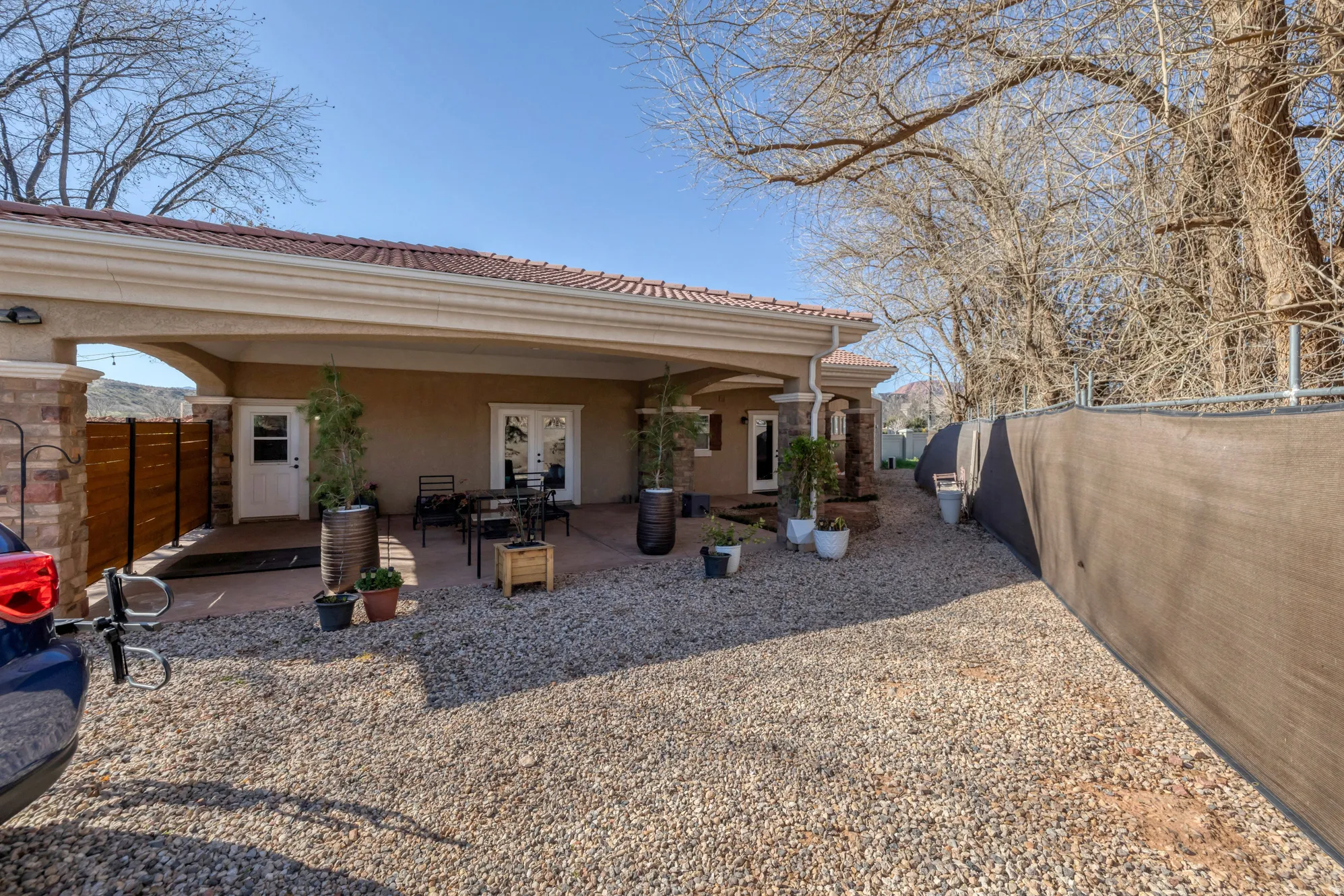 Back of house featuring a fenced backyard, stucco siding, a tile roof, and a patio area