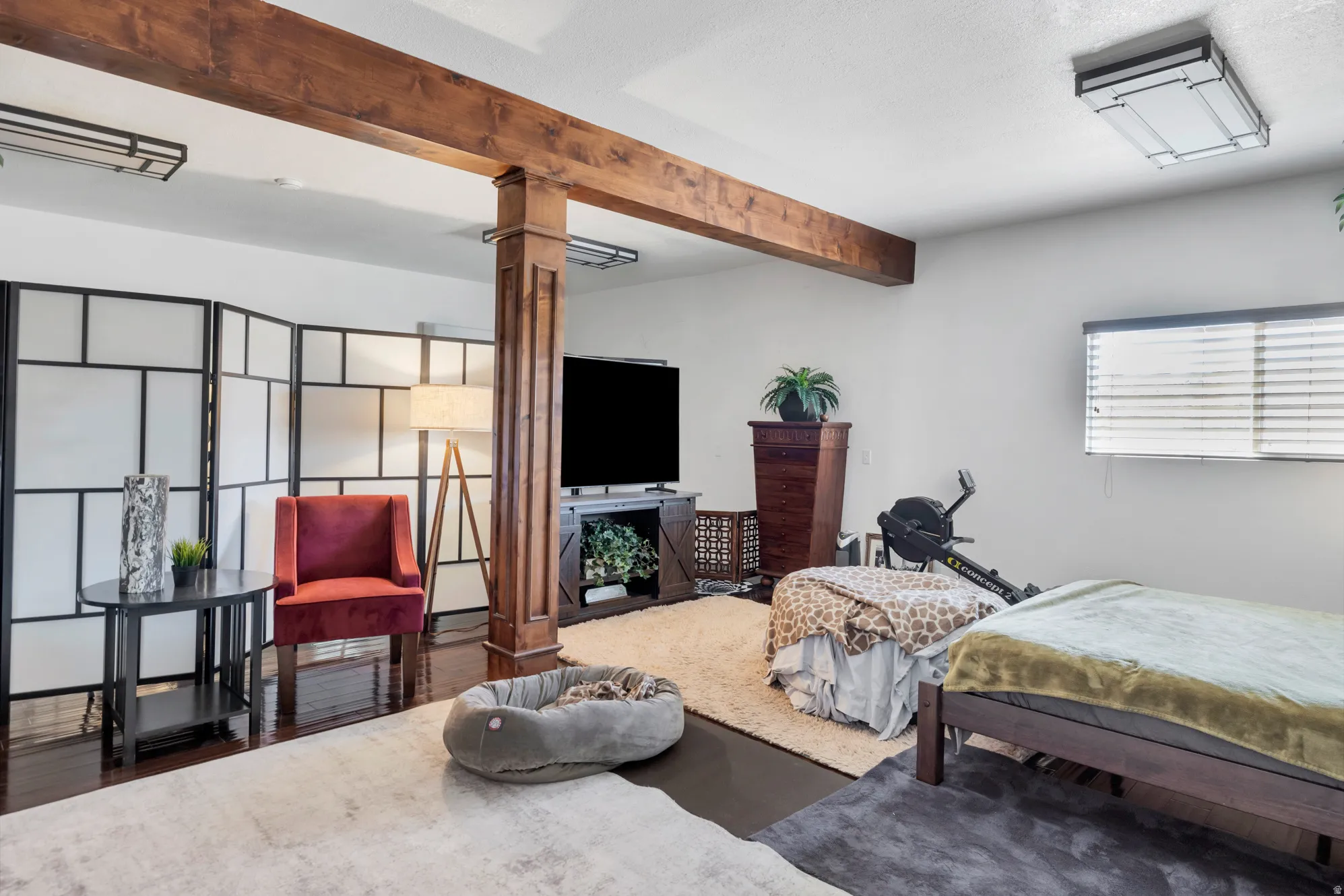 Bedroom with beam ceiling and wood finished floors