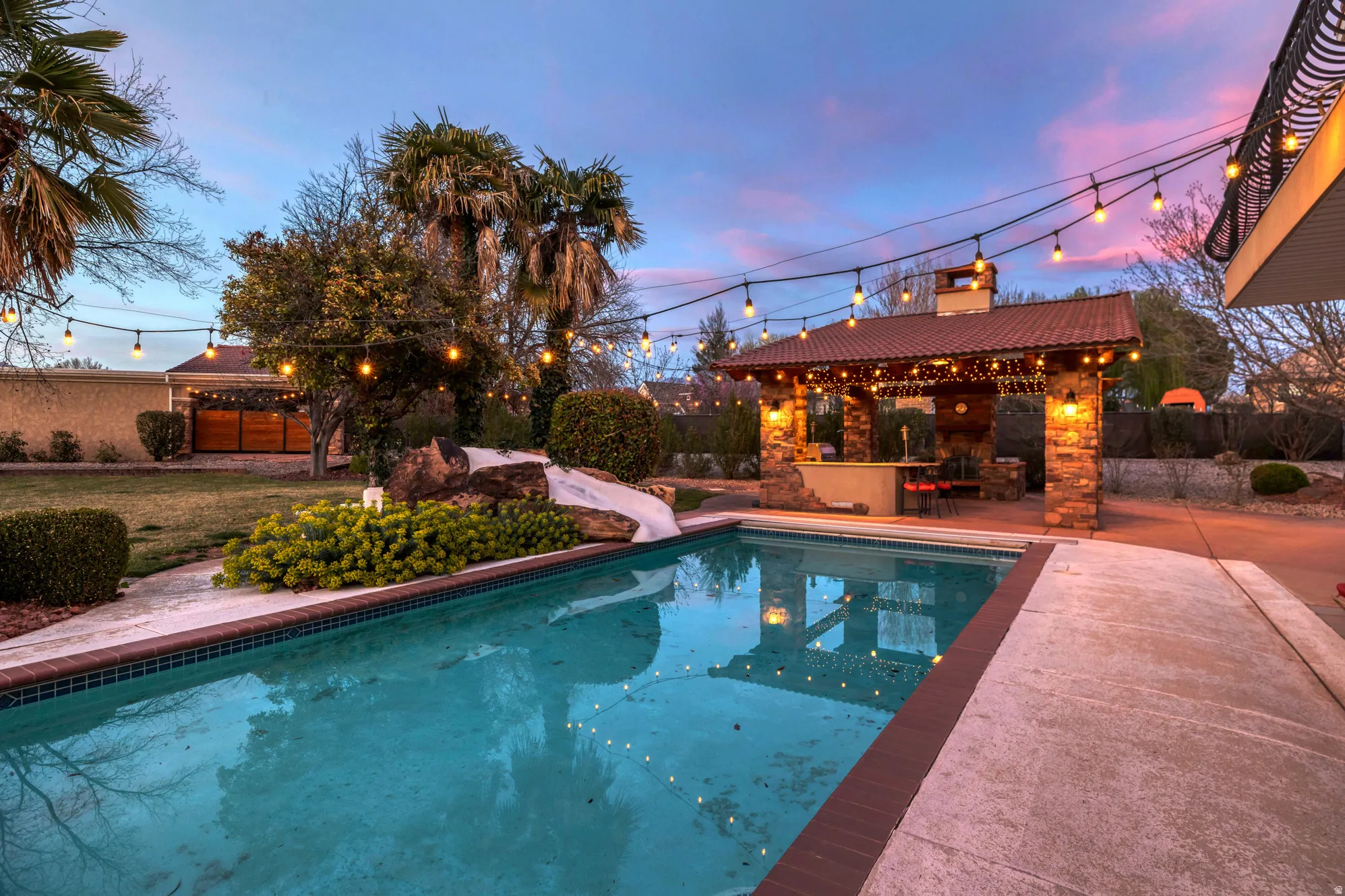 Outdoor pool featuring a patio, a fenced backyard, and a water slide
