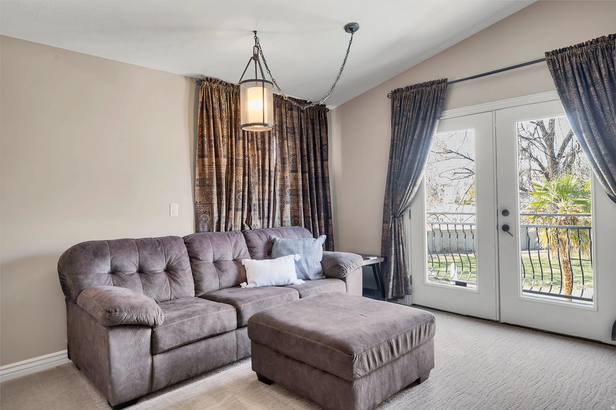 Living room featuring french doors, light colored carpet, and vaulted ceiling