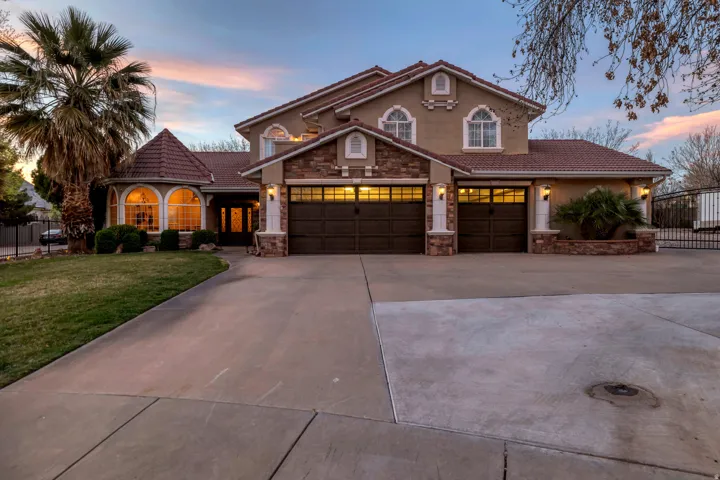 Mediterranean / spanish home featuring concrete driveway, a tiled roof, stone siding, and stucco siding