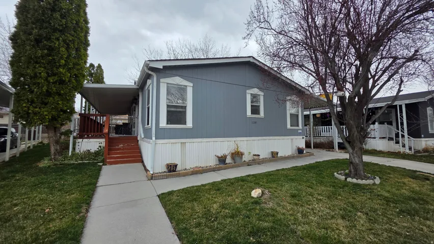 Manufactured / mobile home with a front yard and covered porch