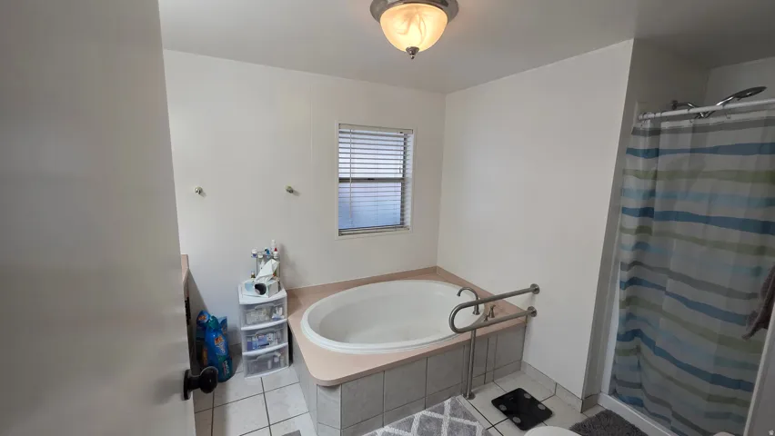 Bathroom featuring a shower stall, a bath, and light tile patterned flooring
