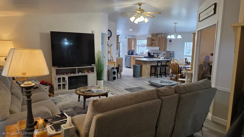 Living area with light wood-style flooring, ceiling fan, and hanging lights
