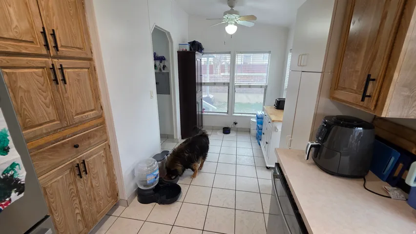 Full bathroom featuring vanity, light tile patterned flooring, ceiling fan, lofted ceiling, and a bath