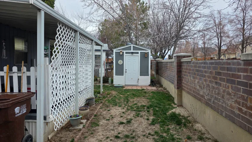 Fenced backyard featuring a storage shed