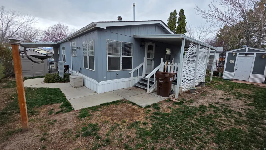 View of front of home with a storage shed, a front yard, and entry steps