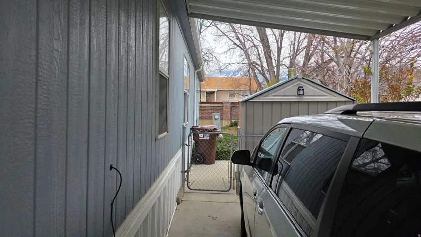 View of side of home with a gate and an outdoor structure