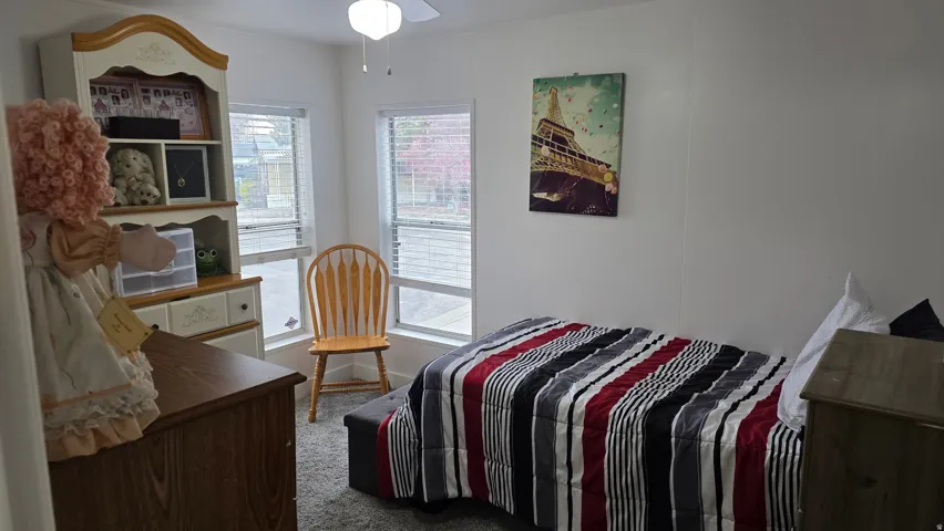 Bedroom with light carpet and a ceiling fan