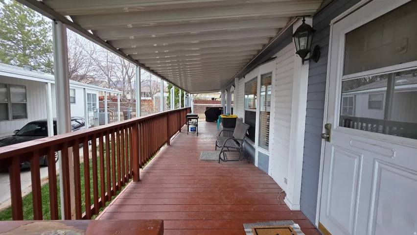 Wooden terrace featuring a grill