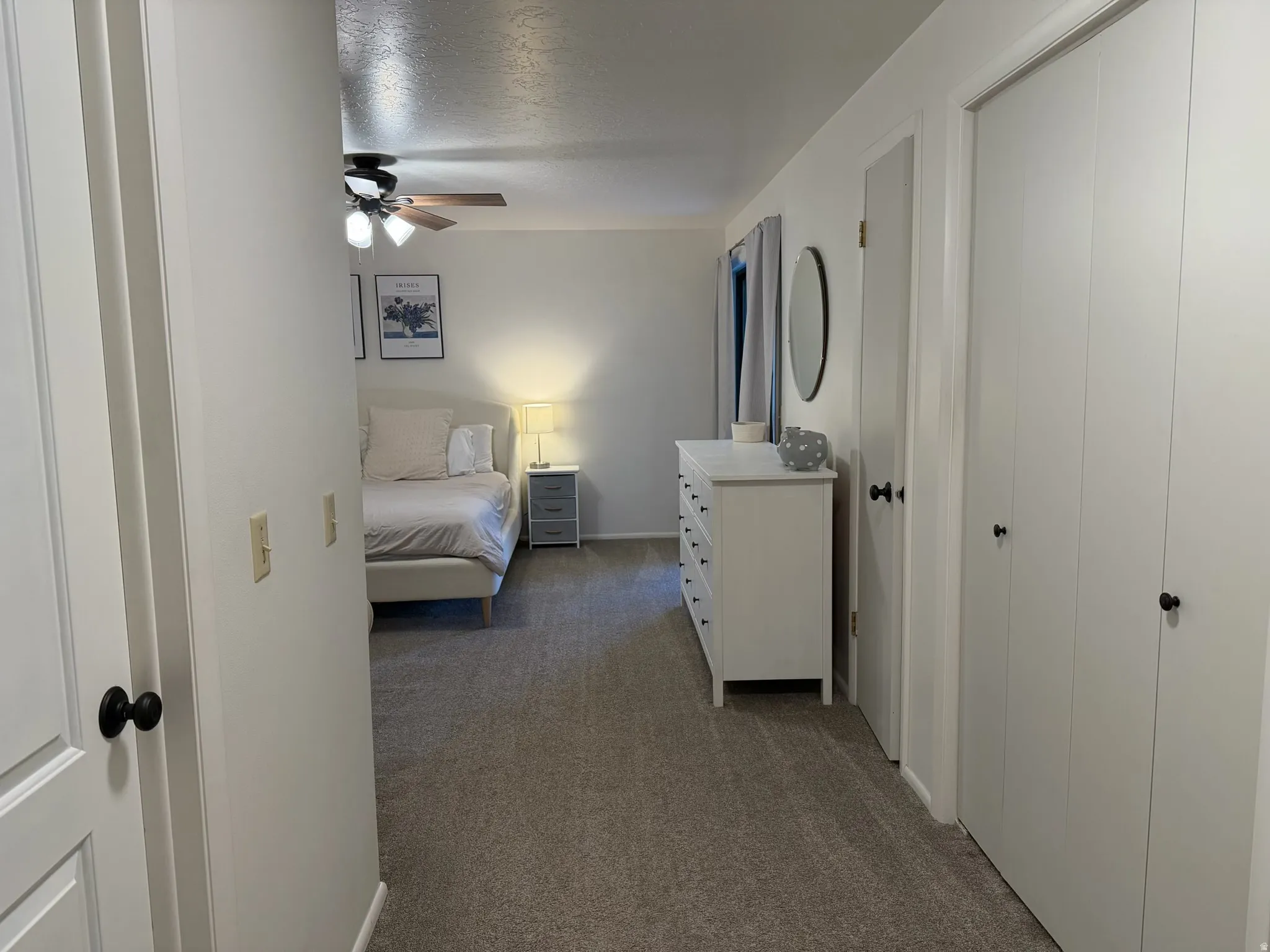 Primary Bedroom featuring dark colored carpet and a ceiling fan
