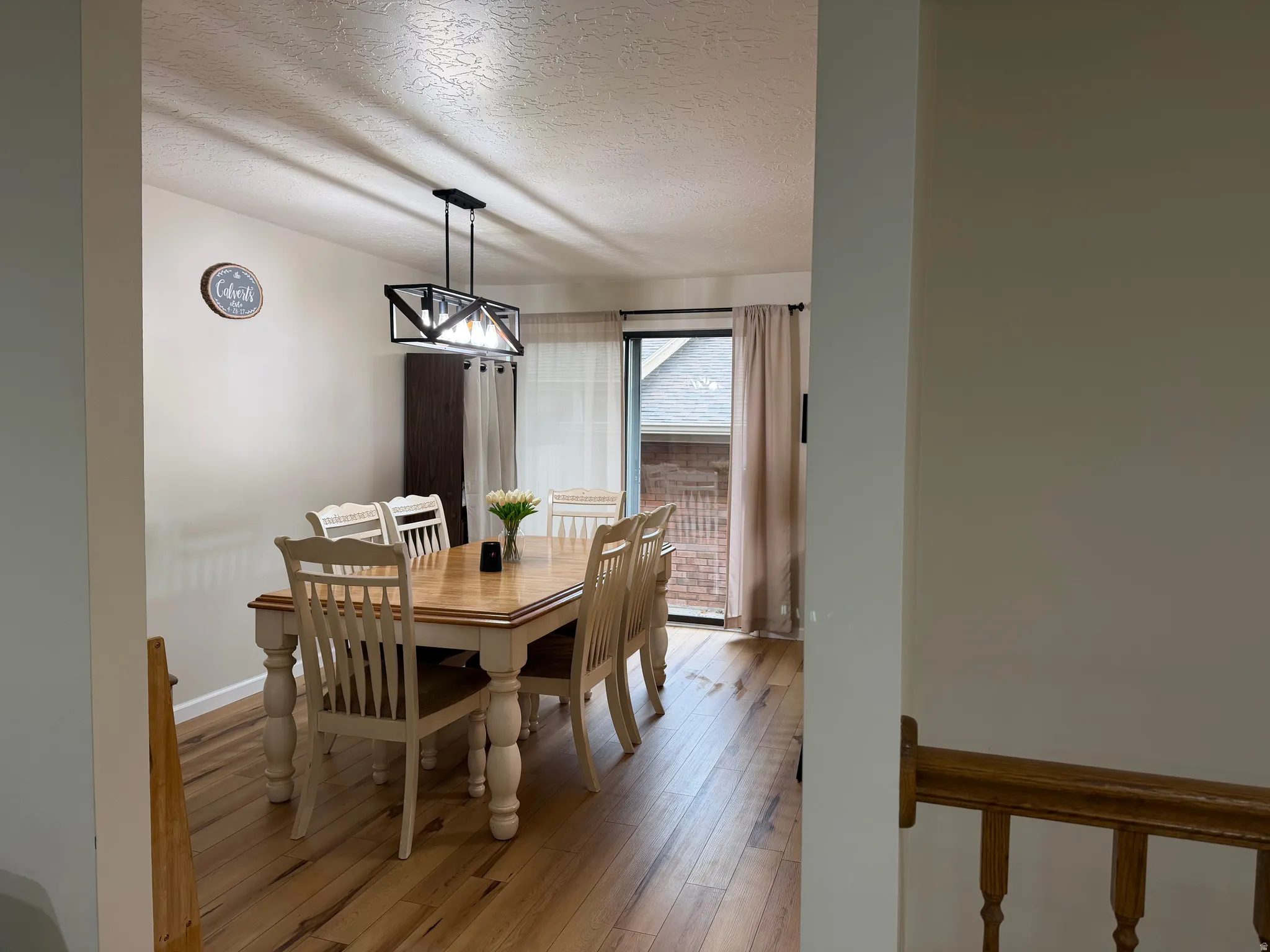 Dining space with a textured ceiling and light wood-style floors