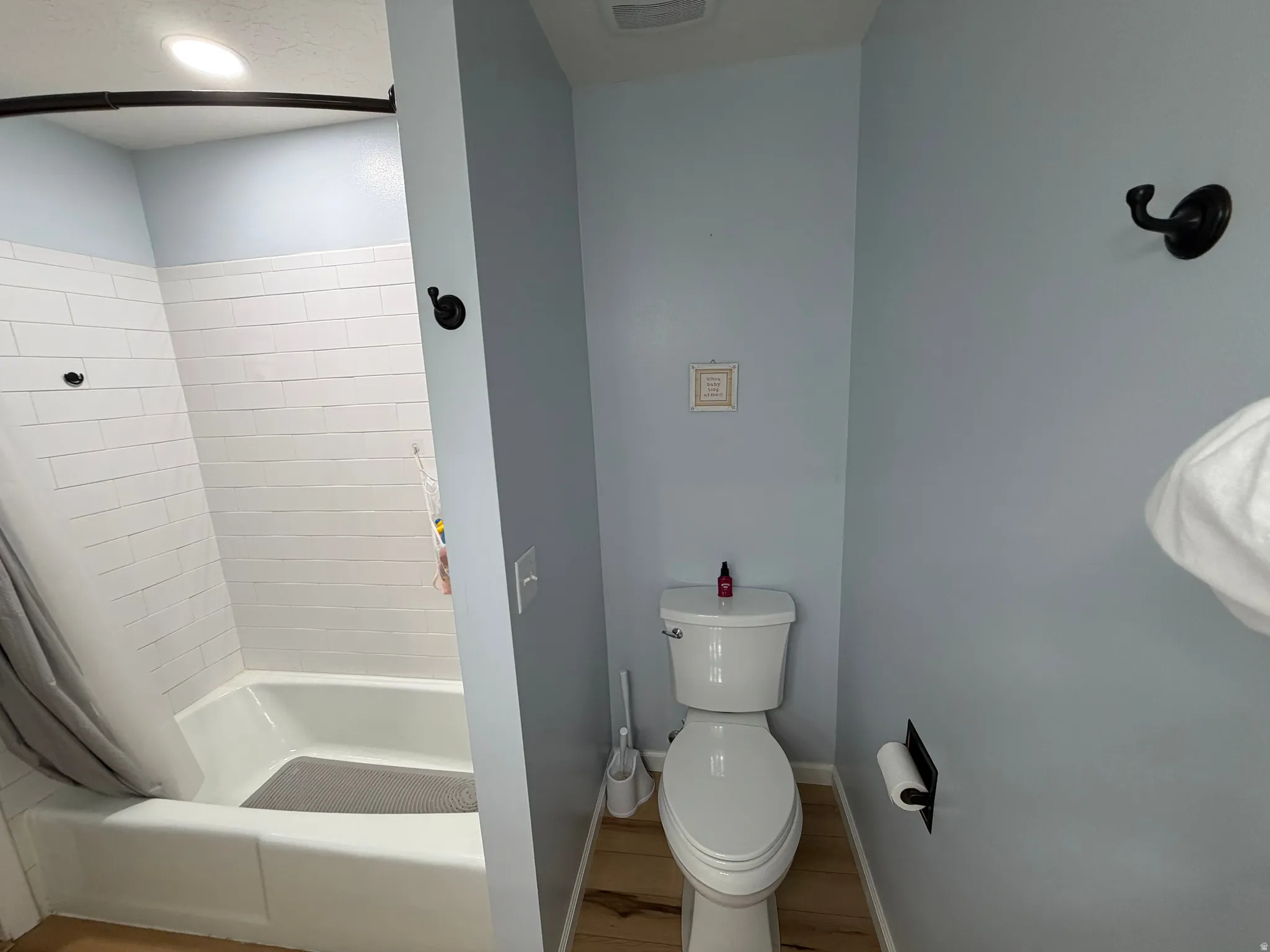 Full bathroom featuring toilet and shower / tub combo with curtain