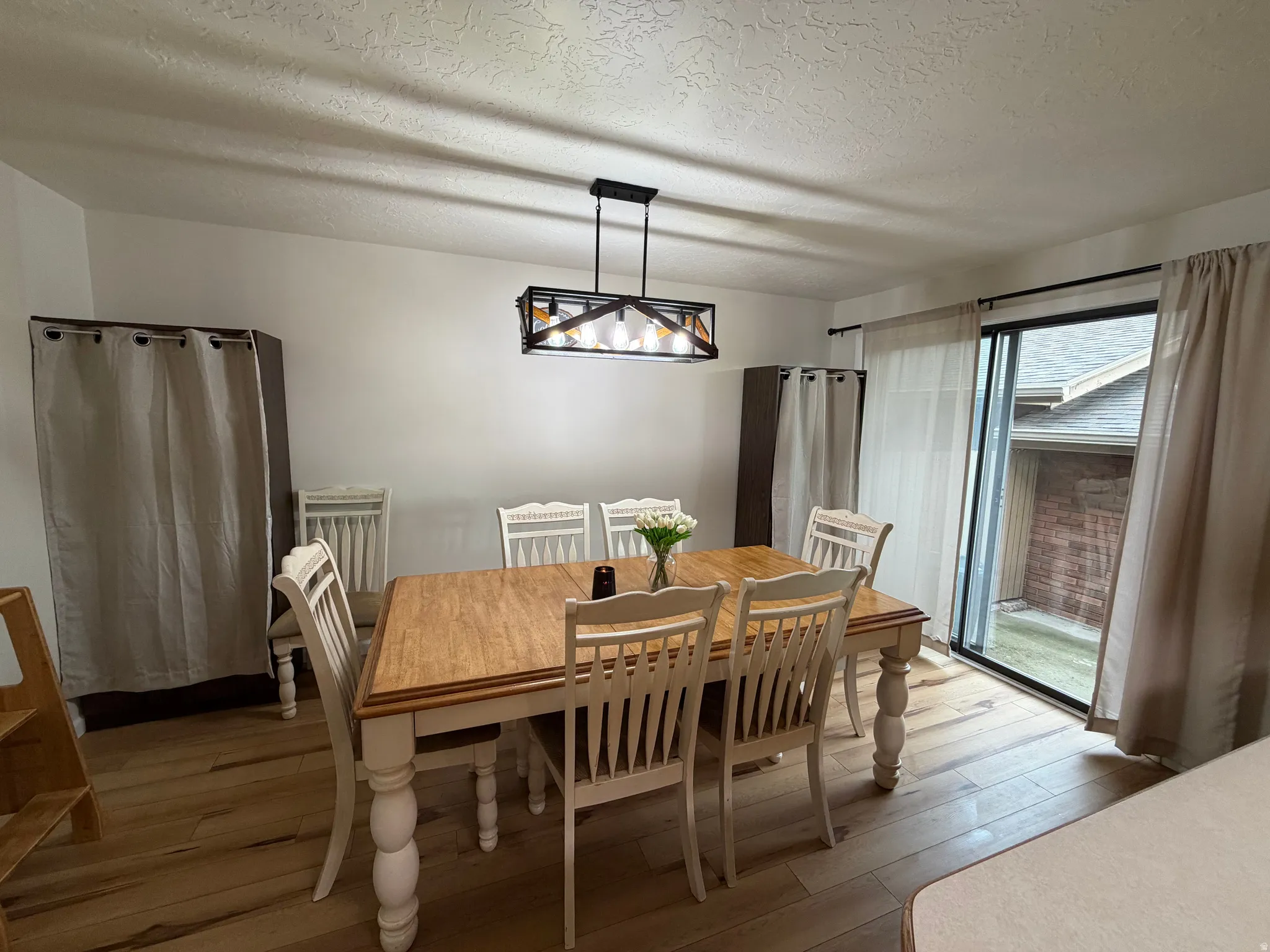 Dining room featuring hardwood / wood-style floors, a textured ceiling, and a chandelier