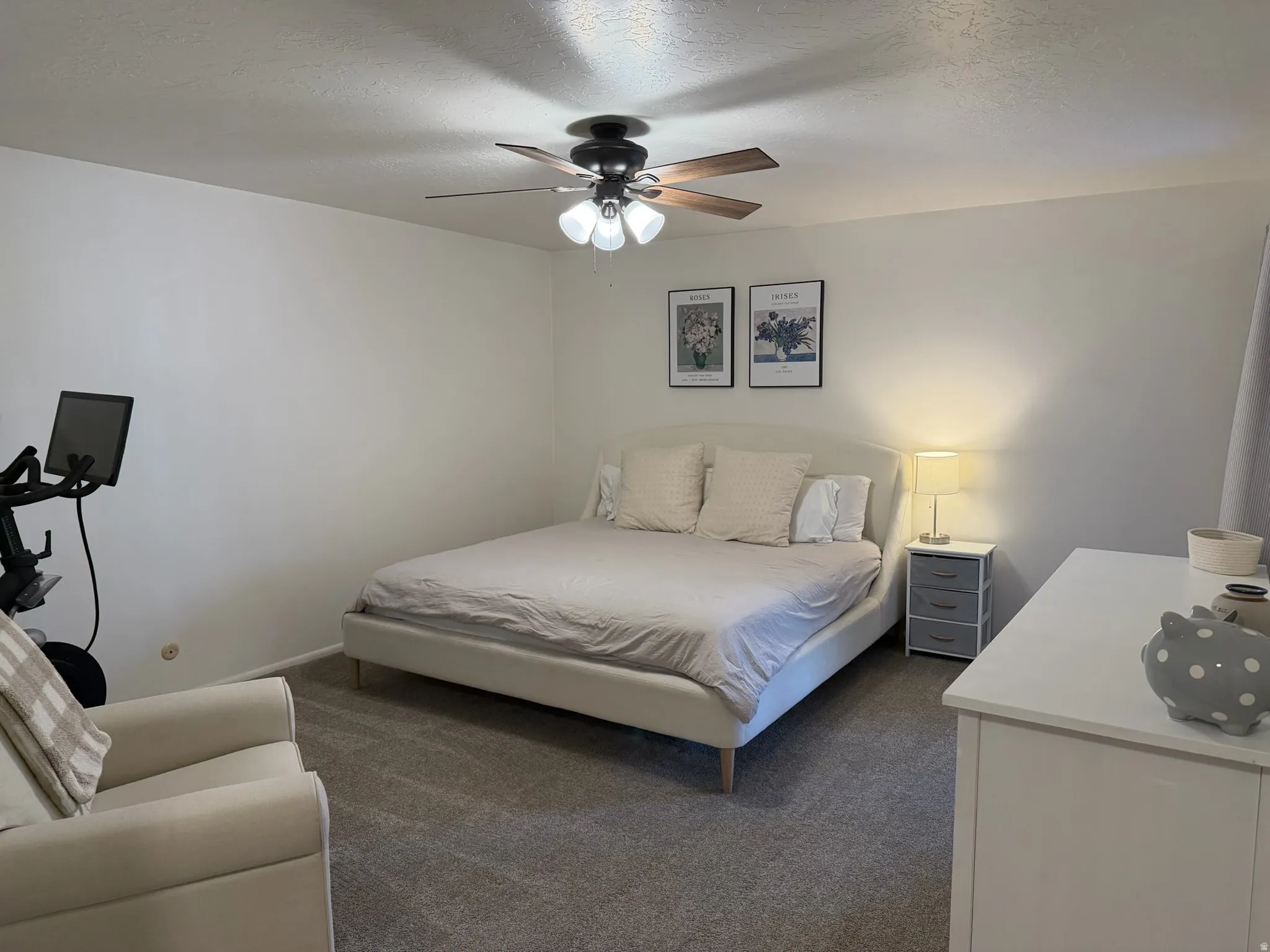 Primary Bedroom featuring a textured ceiling, dark colored carpet, and ceiling fan