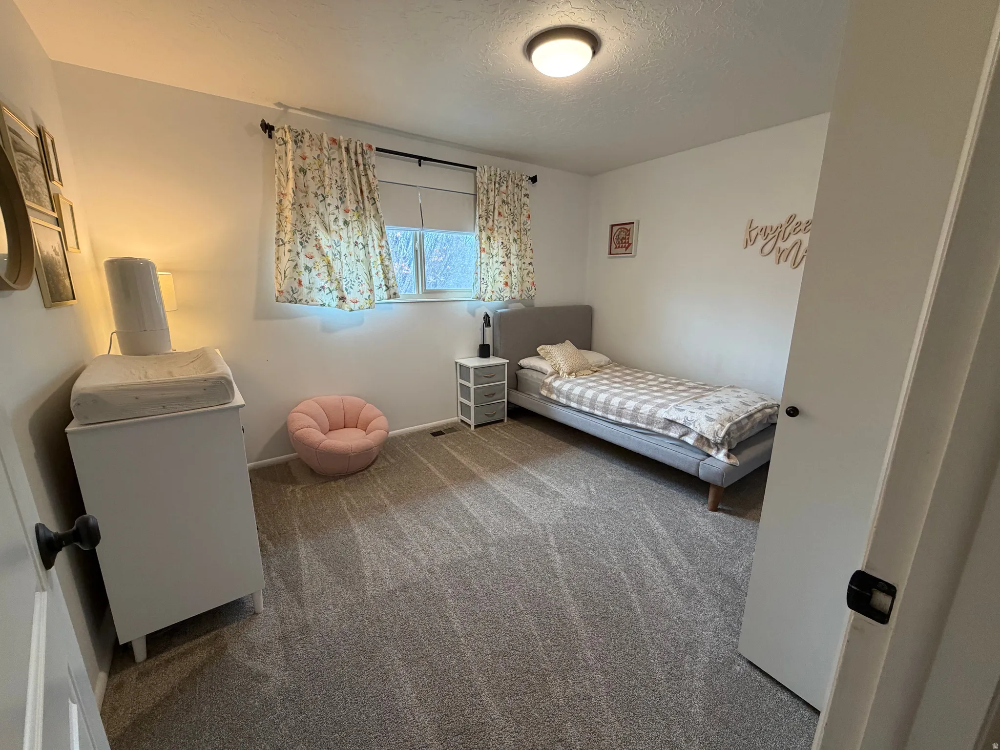 Carpeted bedroom featuring a textured ceiling and baseboards