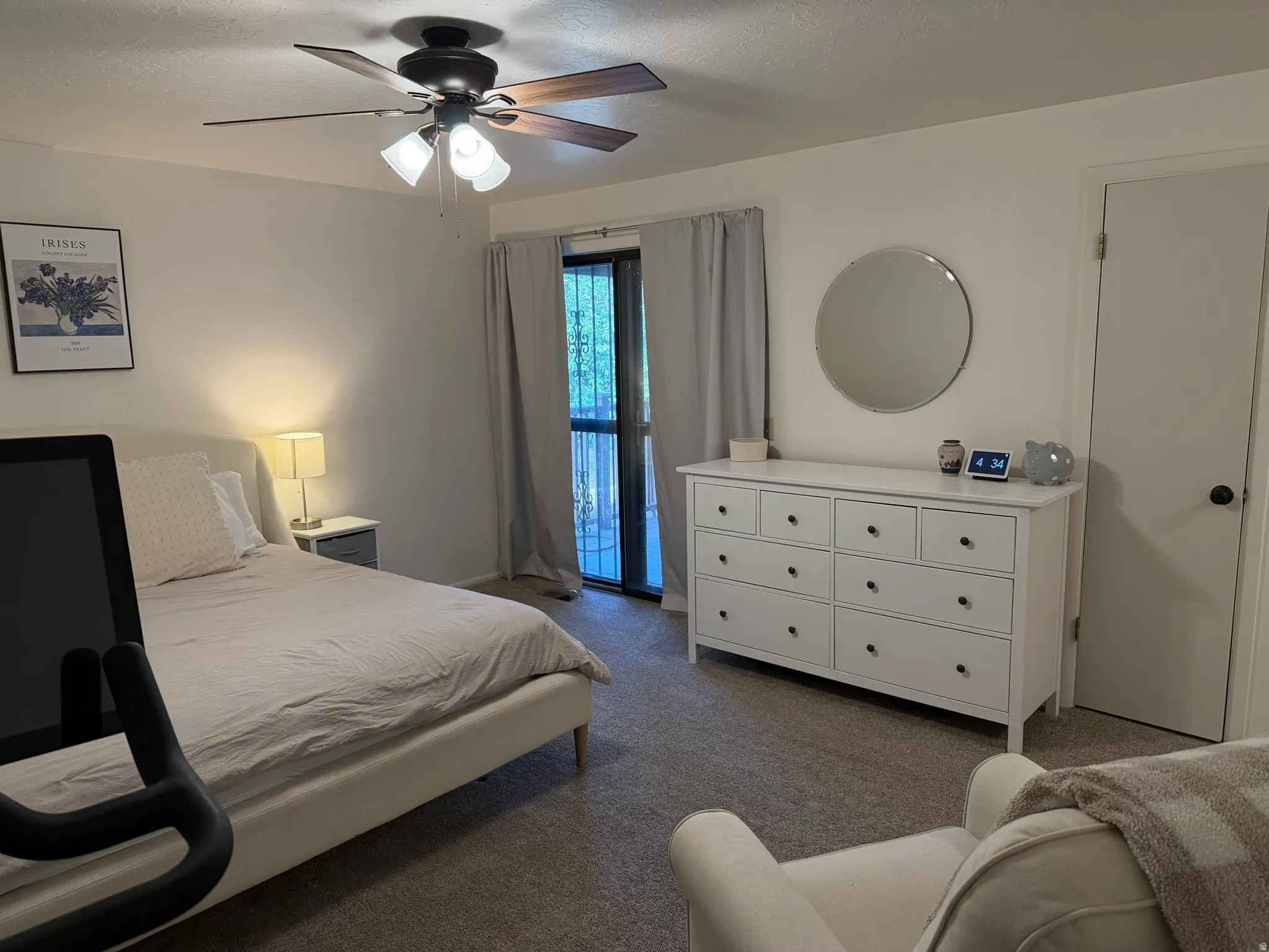 Primary Bedroom featuring a ceiling fan, dark colored carpet, a textured ceiling, and access to exterior