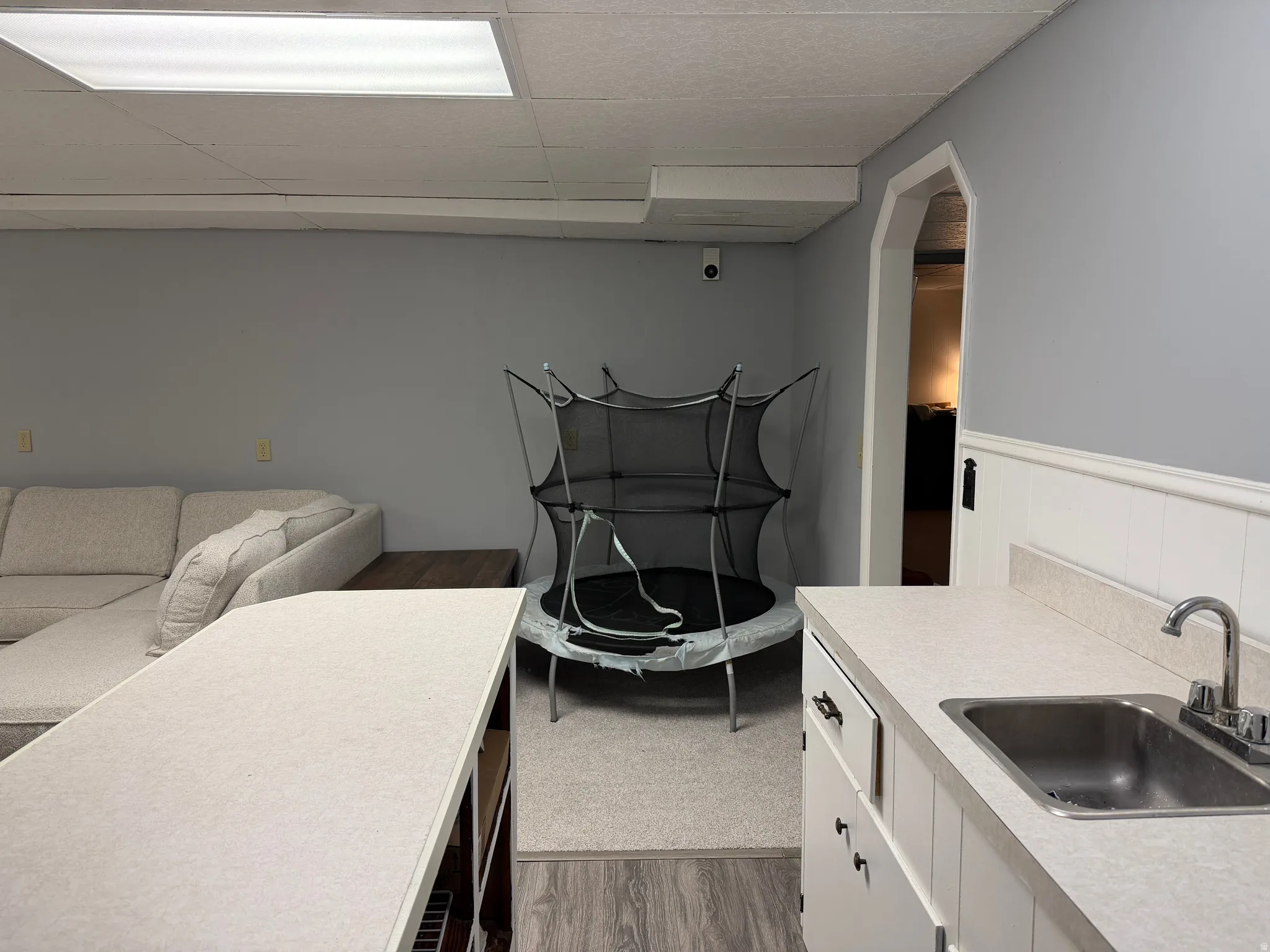 Laundry area featuring dark wood-style floors and a drop ceiling