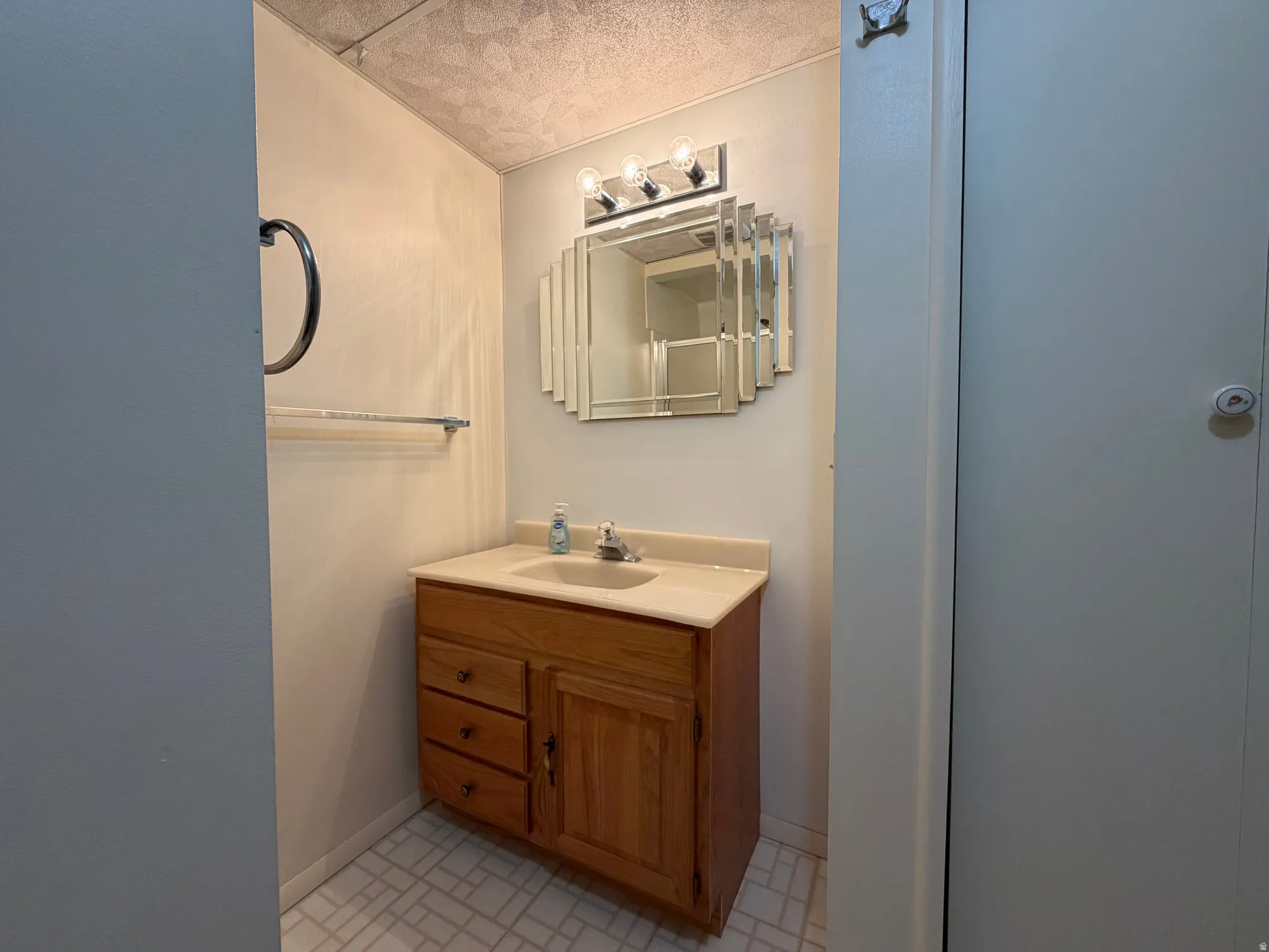 Bathroom with vanity and a textured ceiling