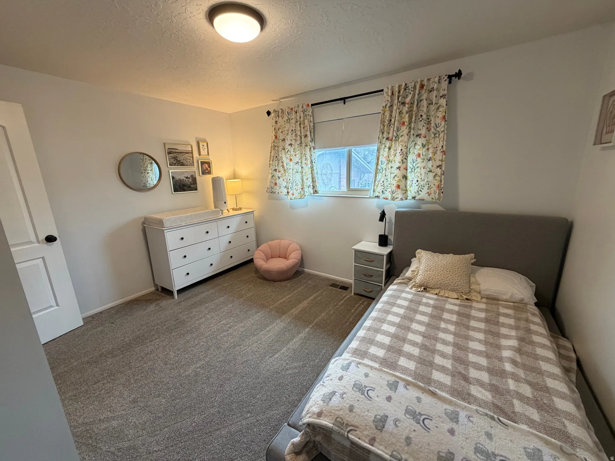 Bedroom featuring dark carpet and a textured ceiling