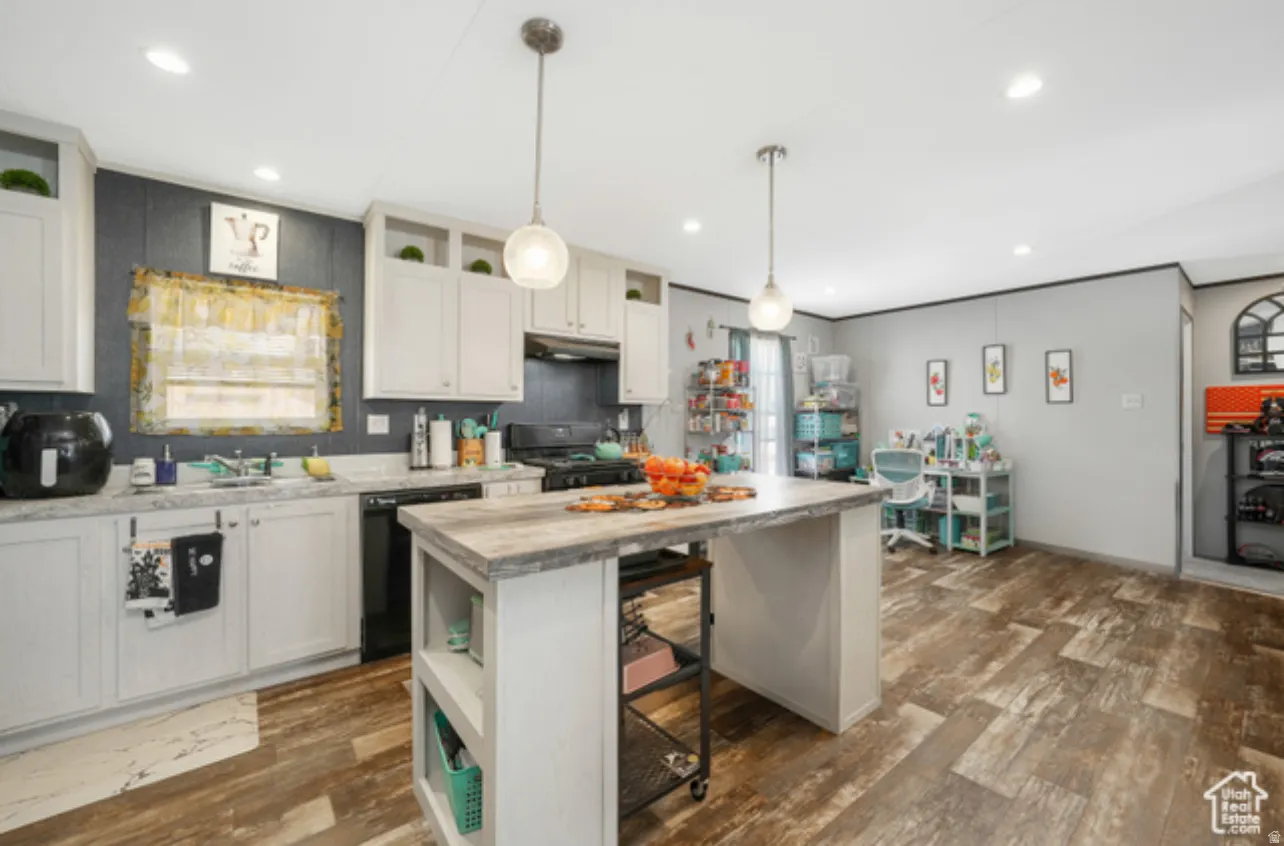 Kitchen with open shelves, a breakfast bar area, a kitchen island, and white cabinetry