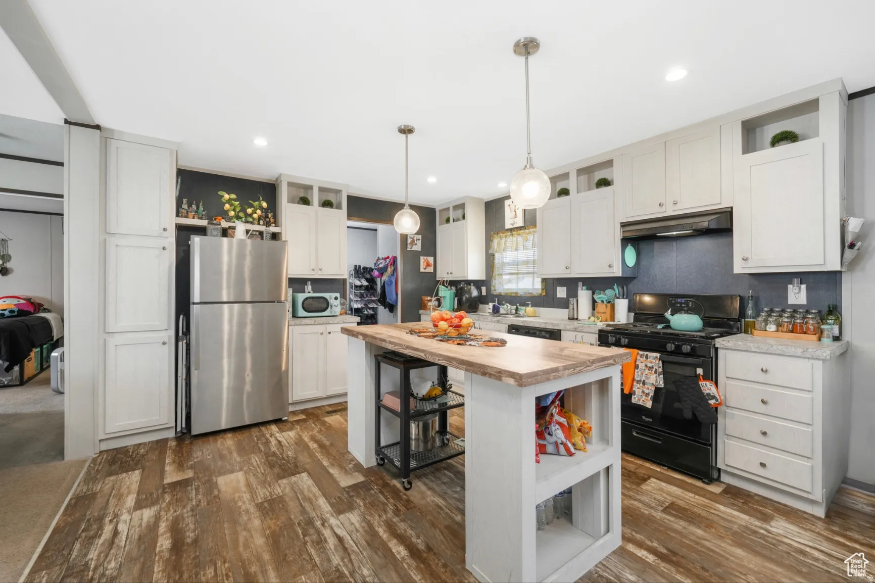 Kitchen featuring open shelves, black appliances, wooden counters, white cabinets, and dark wood-style flooring