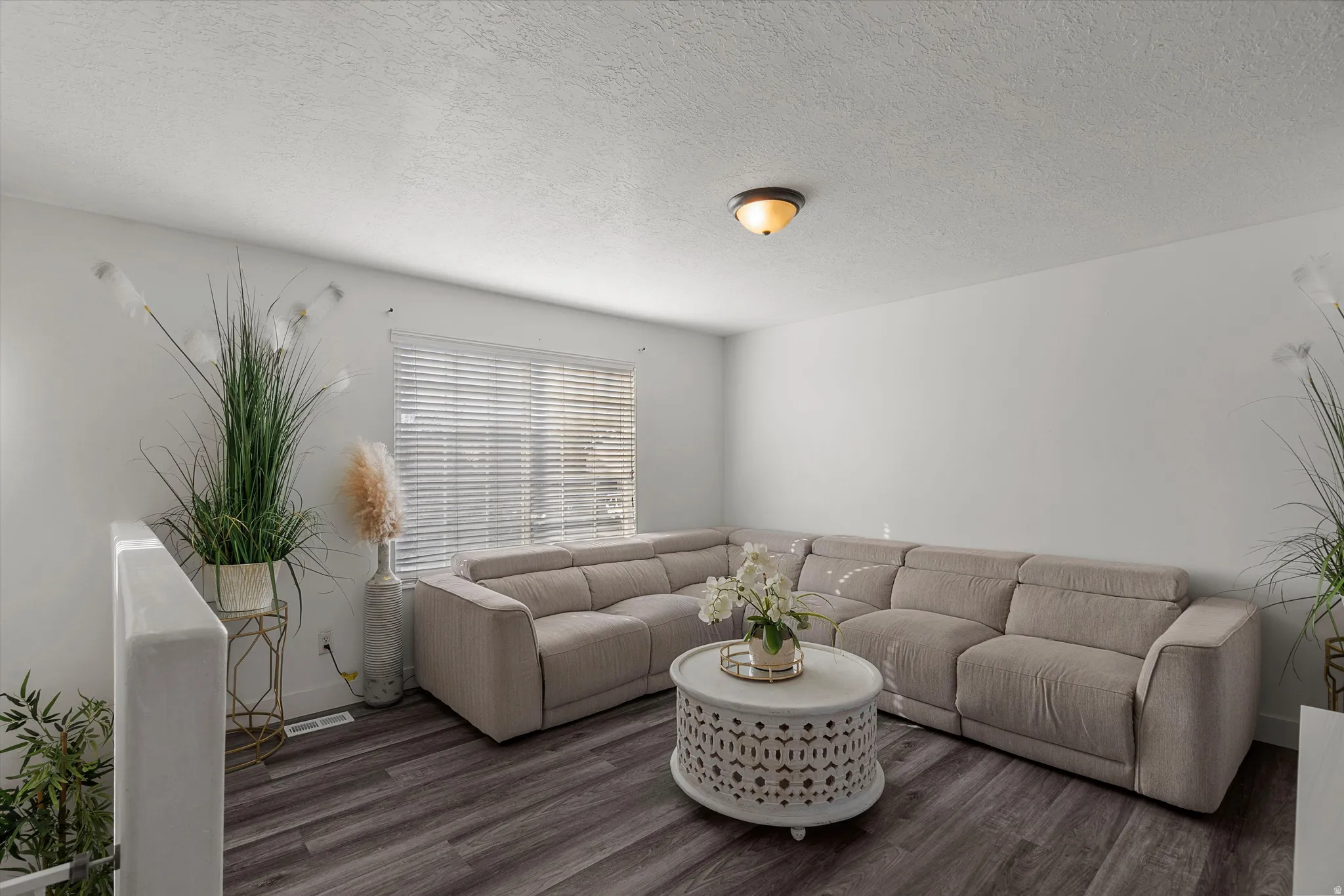 Living area featuring a textured ceiling and wood finished floors