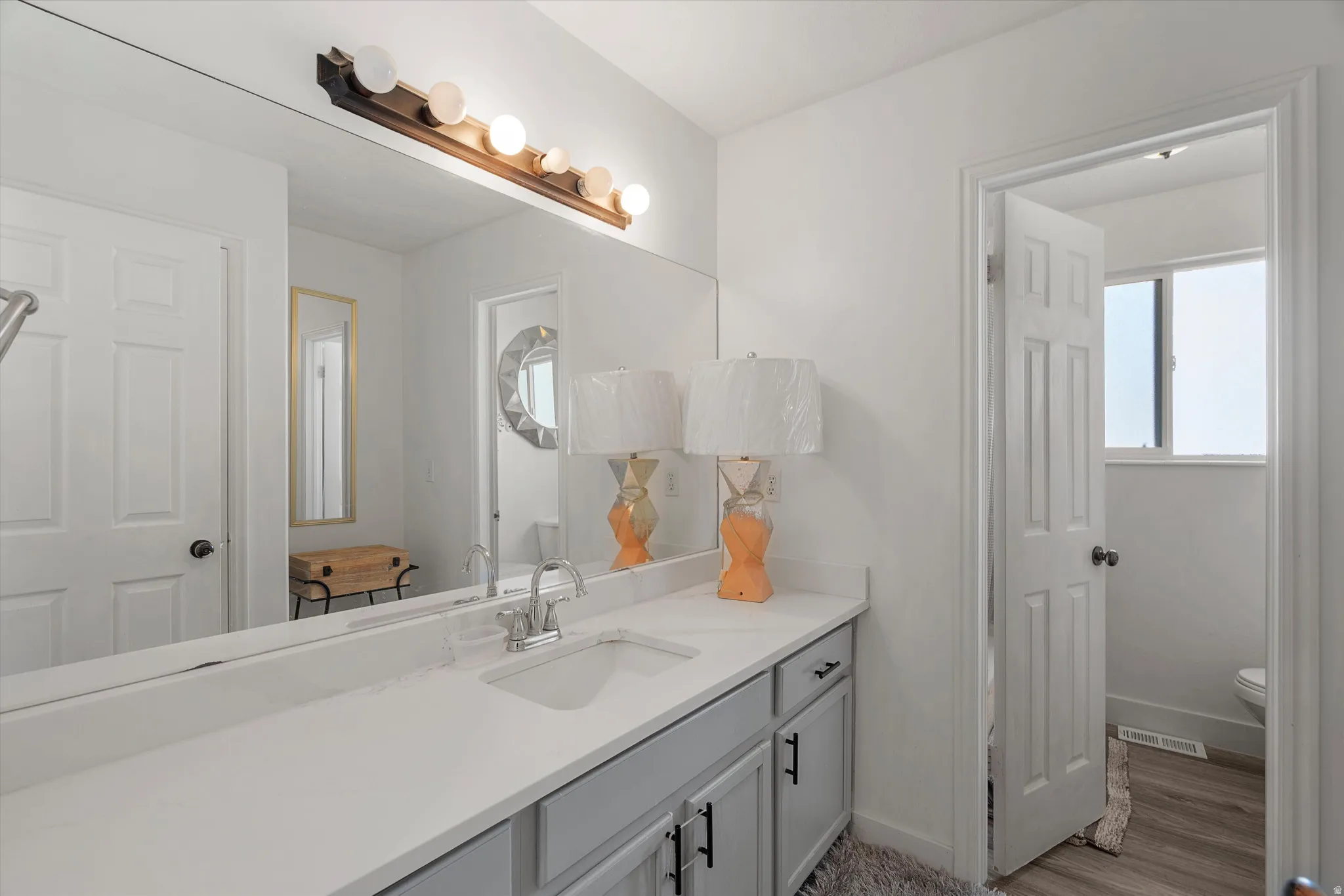 Full bath with vanity and light wood-style floors