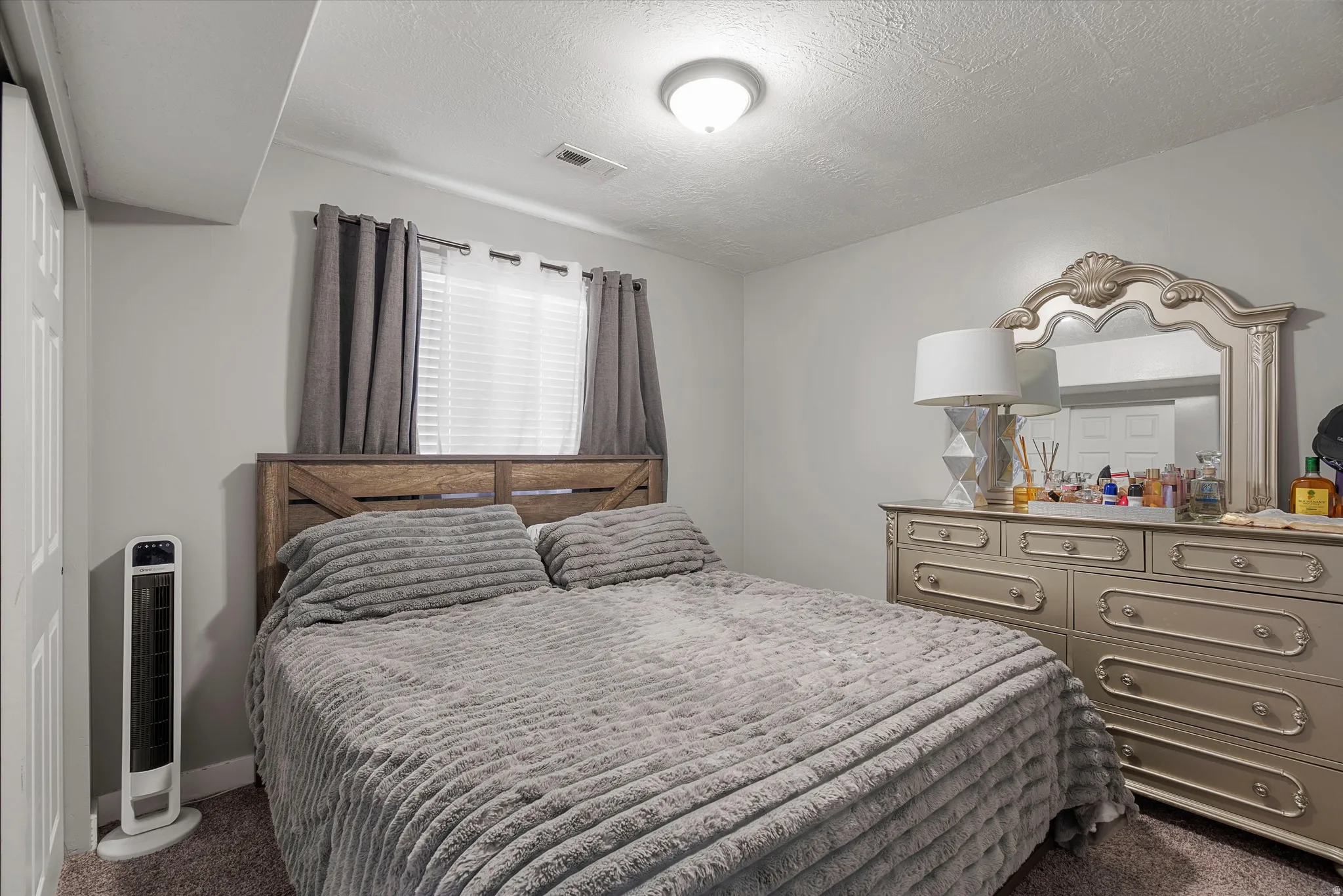 Bedroom featuring dark carpet and a textured ceiling