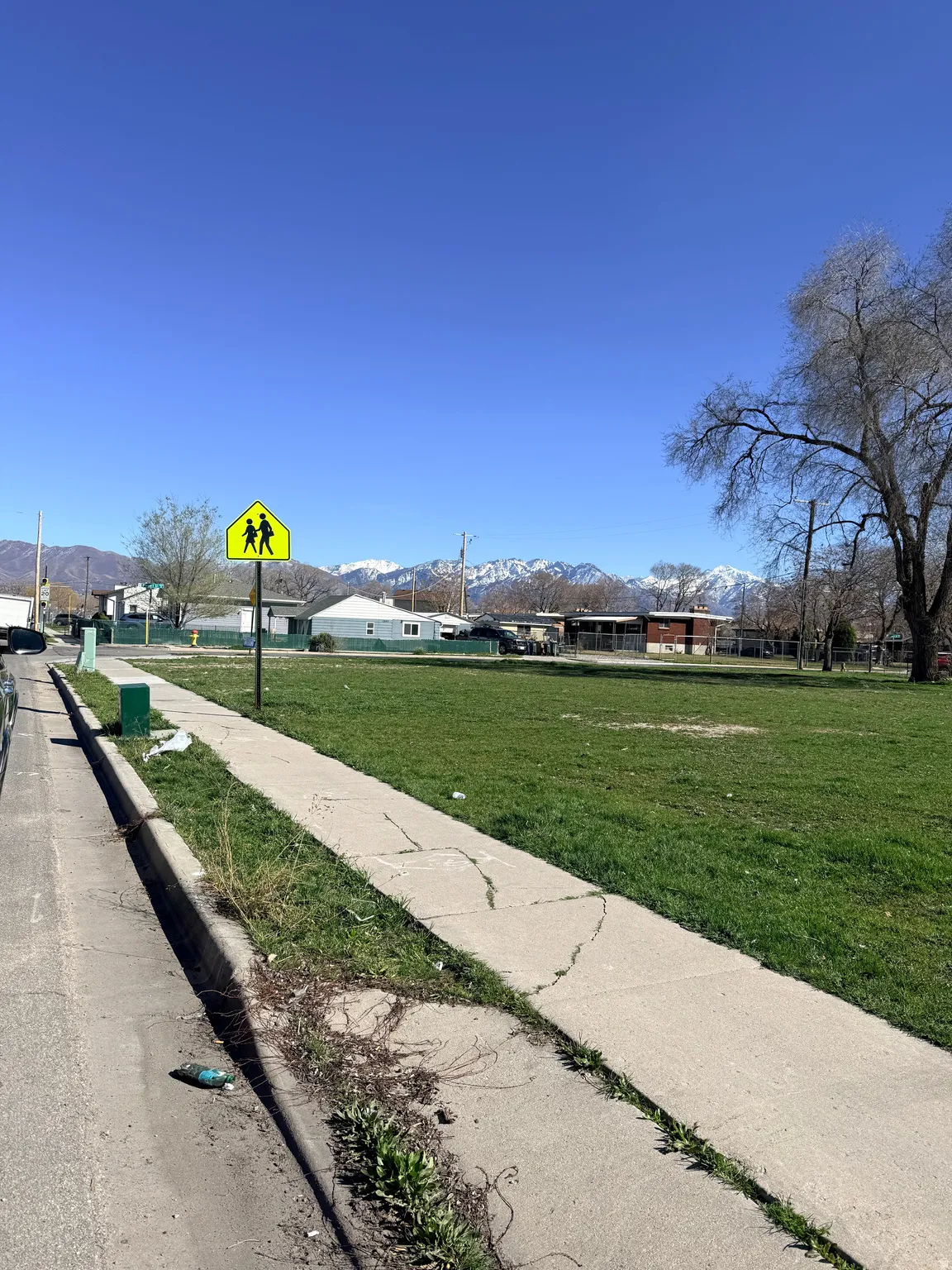 View of street featuring sidewalks, a mountain view, curbs, and traffic signs